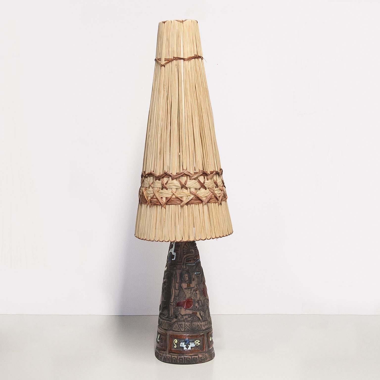 Très belle lampe de table Tiki en céramique exécutée dans le style hawaïen des mers du Sud et un abat-jour original en raphia, fabriquée dans les années 1950 par Tilgmans Suède, excellent état vintage.