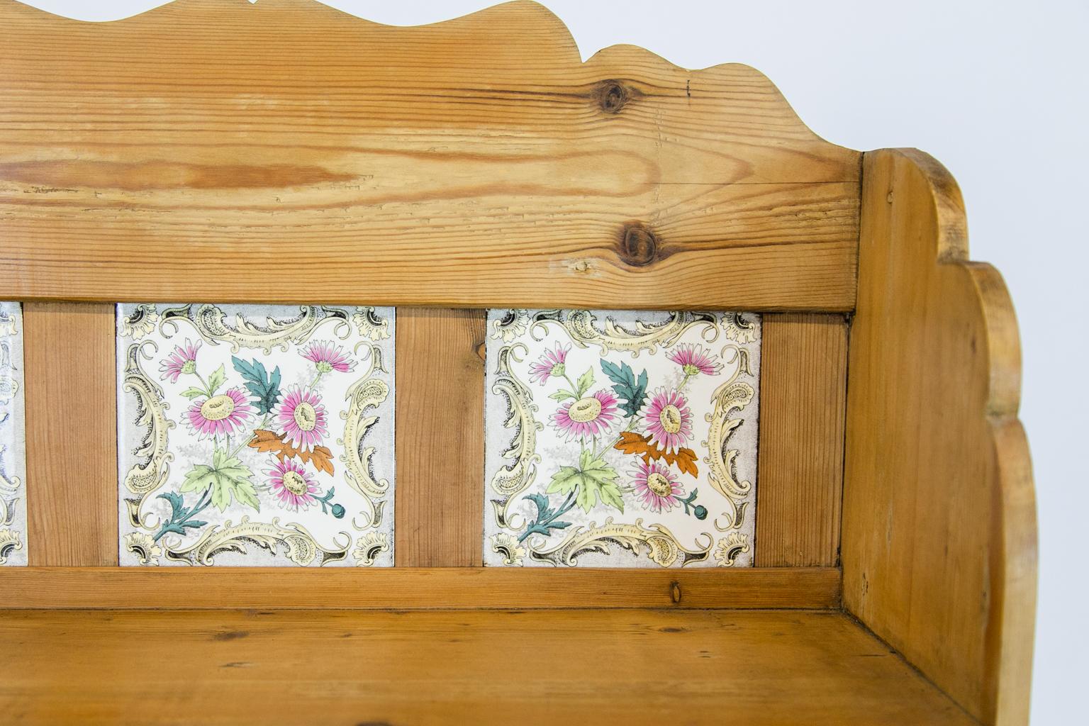 Tiled back wine rack, with three antique floral tiles made by H&R Johnson Tiles Ltd. There are two drawers and two cupboard doors made from antique reclaimed pine in the late 20th century.
   