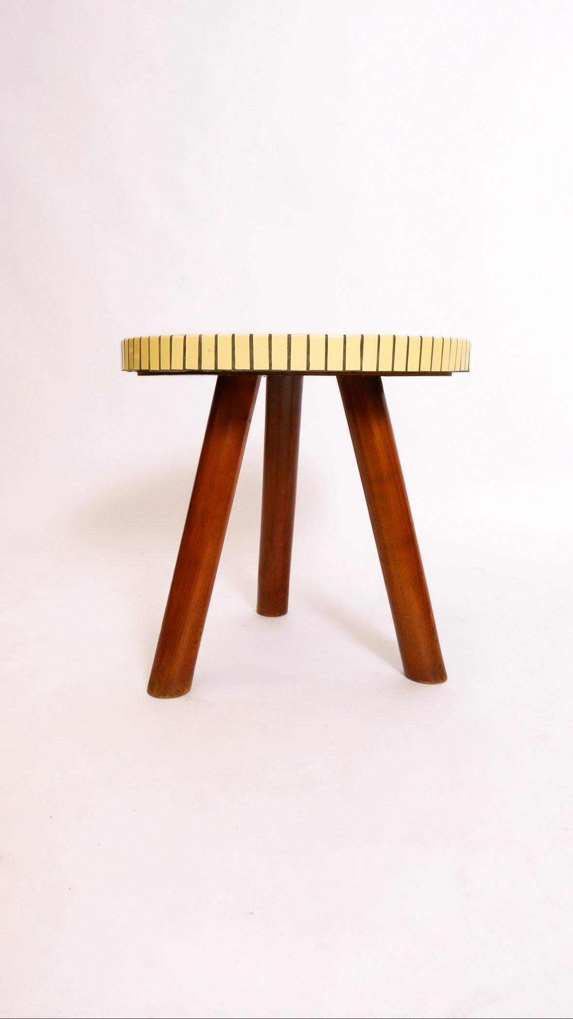Il s'agit d'une délicieuse table dans le style d'Otto Færge. Fabriqué par un ébéniste danois vers les années 1950-60, il s'agit d'un plateau en mosaïque de carreaux de céramique sur une base en hêtre massif teinté. Trois pieds club assurent la