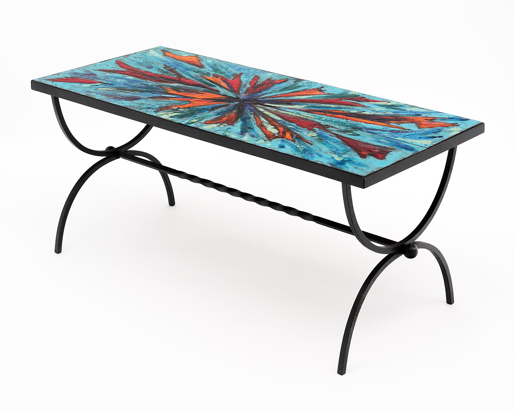 Coffee table from Vallauris on the French Riviera. This piece has a structure of hand-hammered forged iron. It is covered with thick terracotta hand painted tiles with an abstract motif in vivid colors.