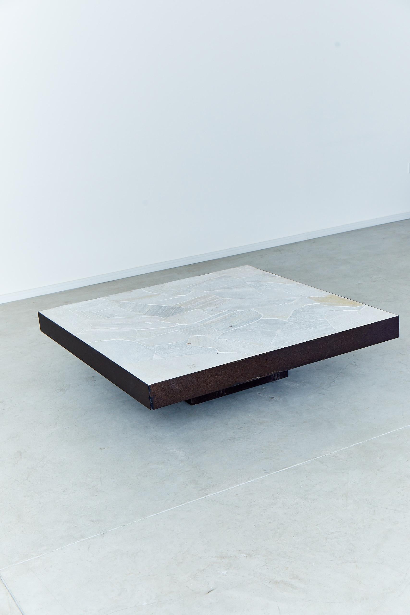 La table basse Tiles, conçue par Arthur Casas, est une création solide et élégante dans une optique de design minimaliste. La structure est en acier et le sommet est fait d'une belle pierre appelée 