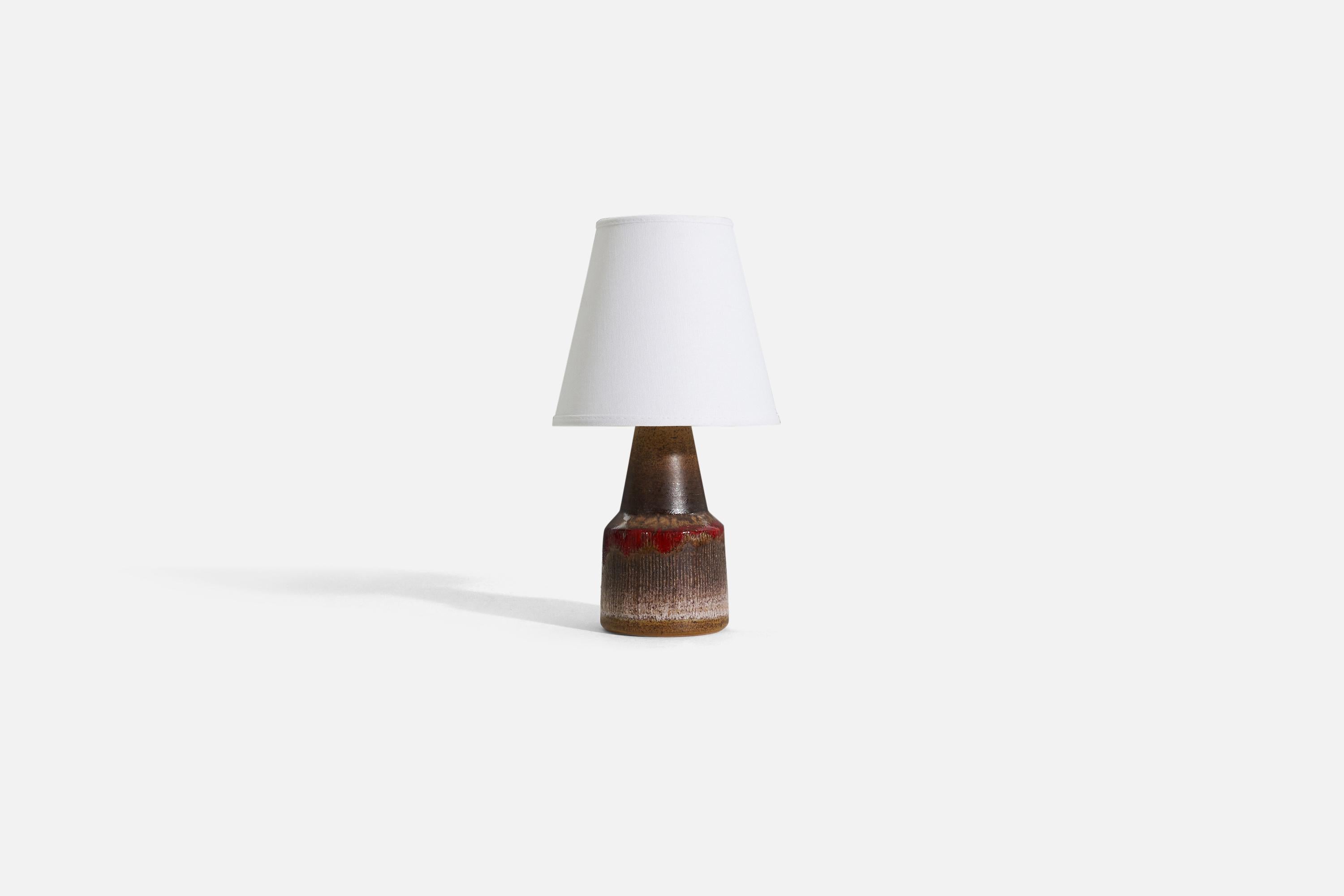 A brown, orange, and red glazed stoneware table lamp by Tilgmans Keramik, 1950s. 

Sold without lampshade. 

Dimensions of lamp (inches) : 9.125 x 4 x 4 (H x W x D).
Dimensions shade (inches) : 4 x 7 x 6.25 (T x B x H).
Dimension of lamp with