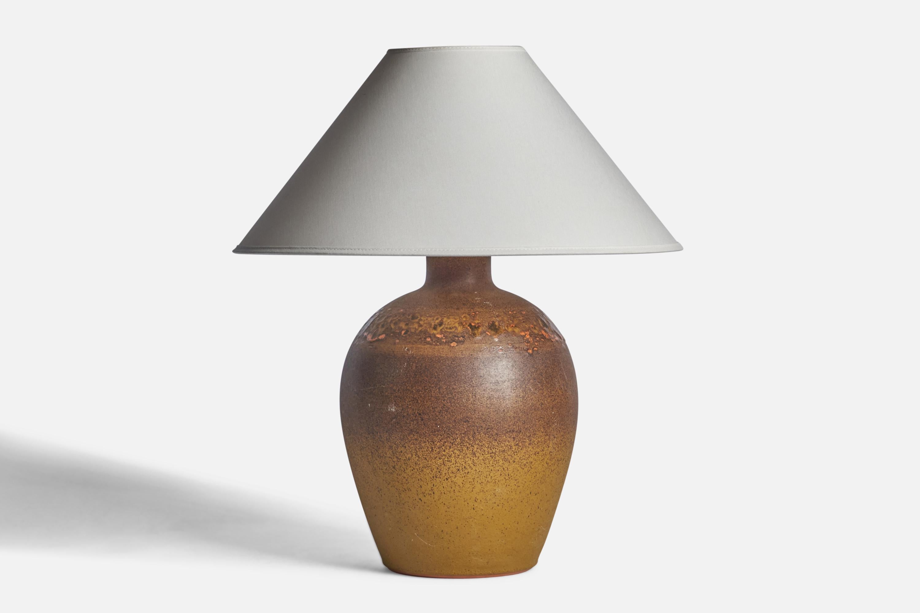 A brown and yellow-glazed stoneware table lamp designed and produced by Tilgmans Keramik, Sweden, 1960s.

Dimensions of Lamp (inches): 14.25” H x 8” Diameter
Dimensions of Shade (inches): 4.5” Top Diameter x 16” Bottom Diameter x 7.25” H
Dimensions
