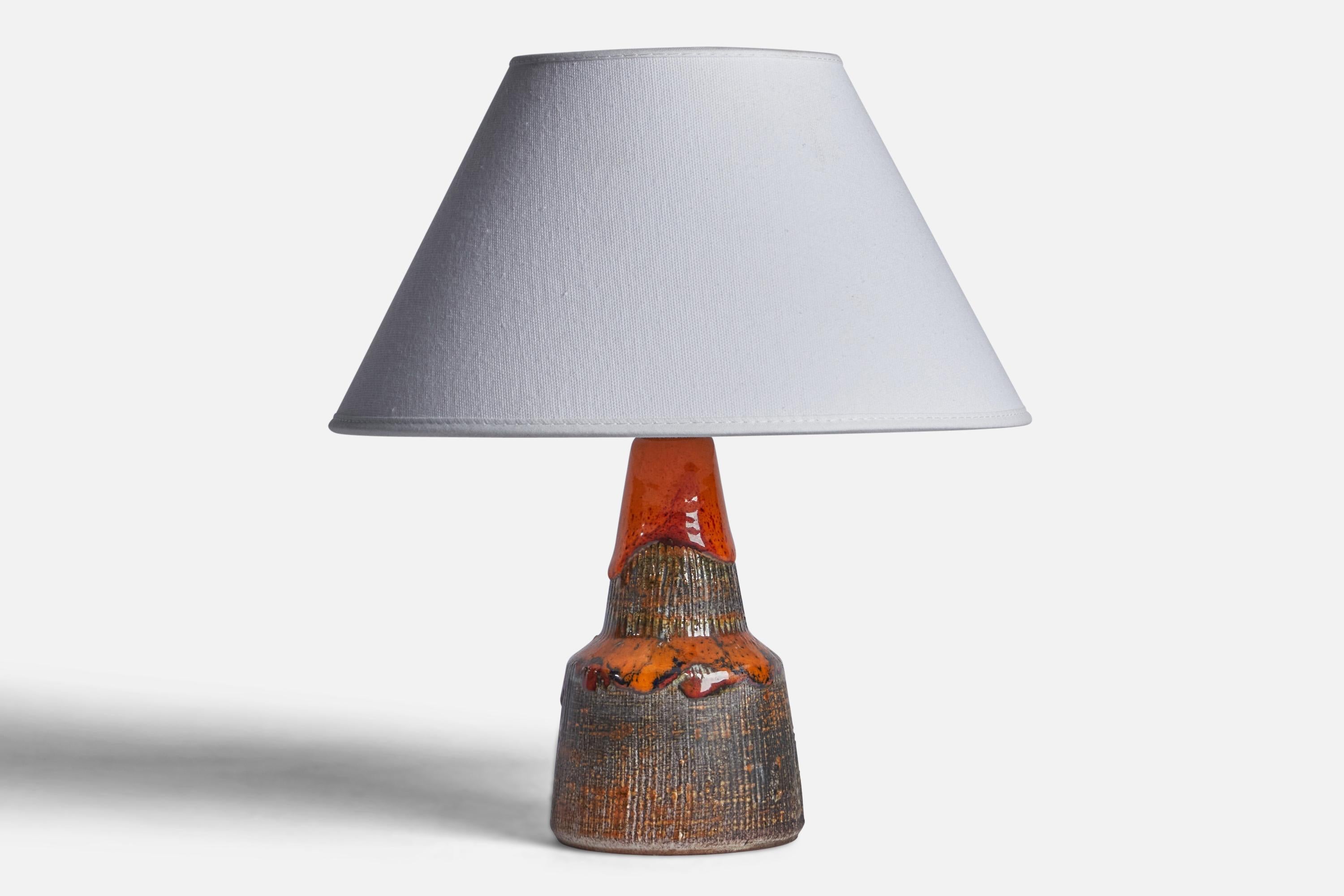 A red, brown and orange-glazed stoneware table lamp designed and produced by Tilgmans Keramik, Sweden, 1960s.

Dimensions of Lamp (inches): 8” H x 3.75” Diameter
Dimensions of Shade (inches): 7” Top Diameter x 10” Bottom Diameter x