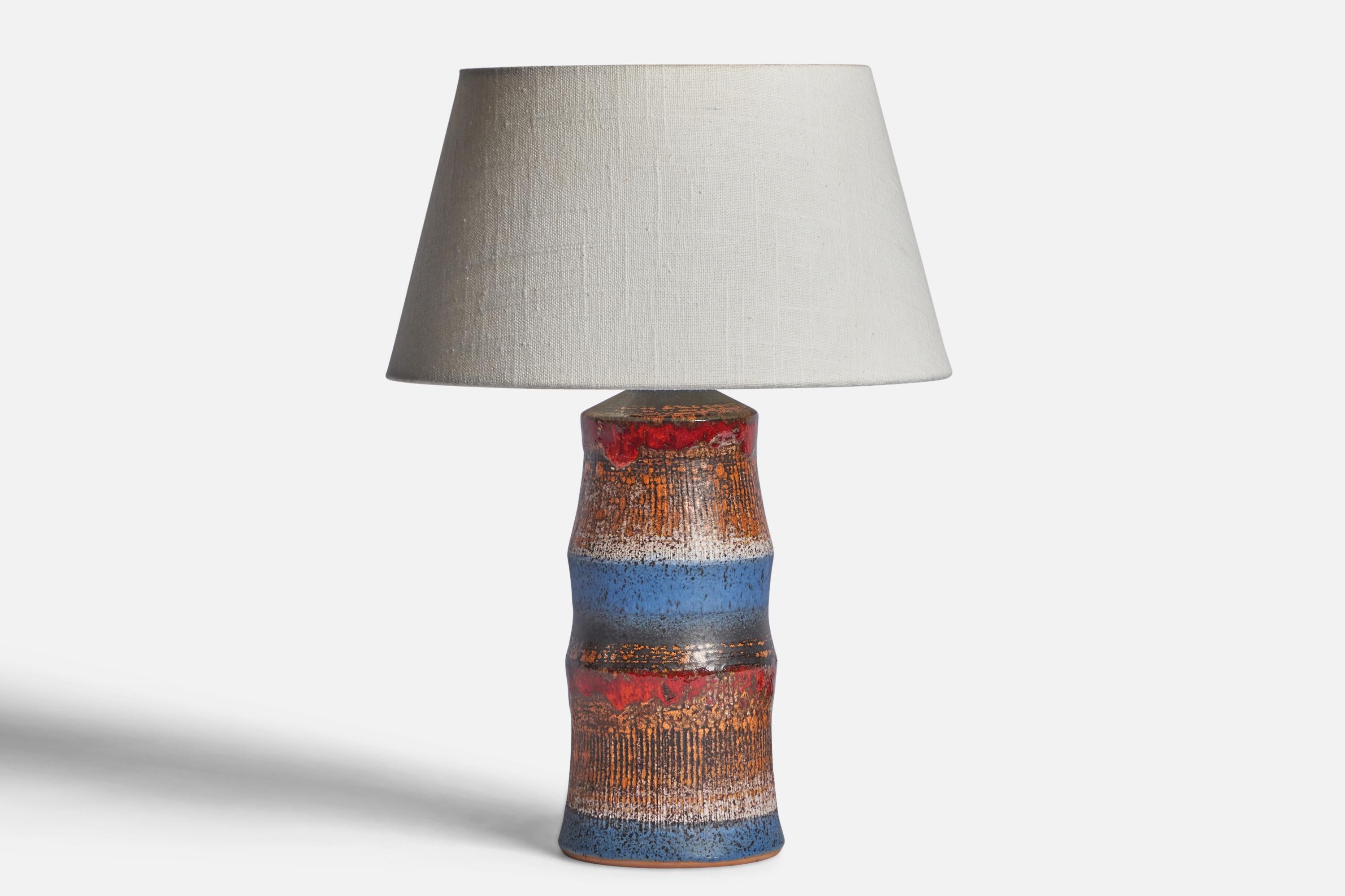 A brown, blue and red-glazed stoneware table lamp designed and produced by Tilgmans Keramik, Sweden, 1960s.

Dimensions of Lamp (inches): 10.75” H x 4” Diameter
Dimensions of Shade (inches): 7” Top Diameter x 10” Bottom Diameter x 5.5” H 
Dimensions