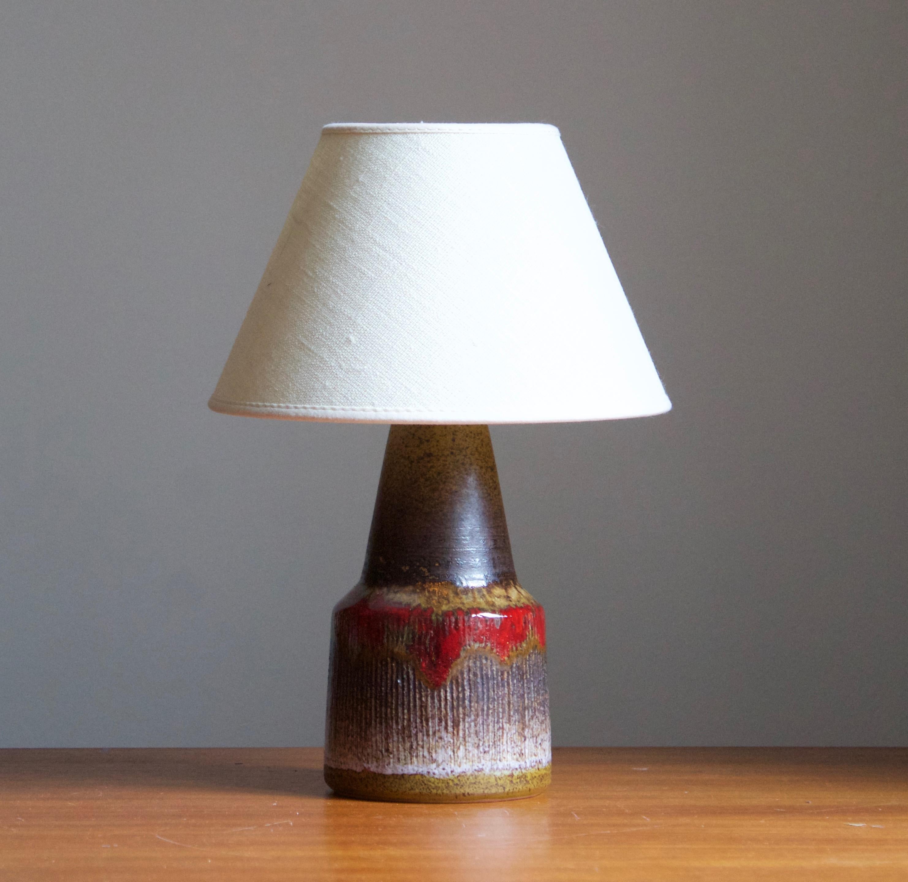 A glazed stoneware table lamp. By Tilgmans Keramik, 1950s. Features a complex glaze combined with incised decor in a style iconic to the producer.

Stated dimensions exclude lampshade. Height includes socket. Sold without lampshade.

Glaze features