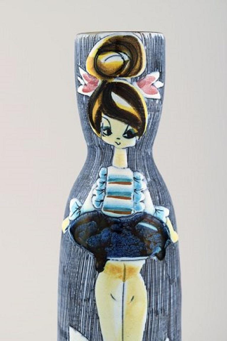 Tilgmans, Sweden. Vase in glazed ceramics with young woman, mid-20th century.
Measures: 25.5 x 7.2 cm.
Signed.
In very good condition with small chip at the bottom.
  