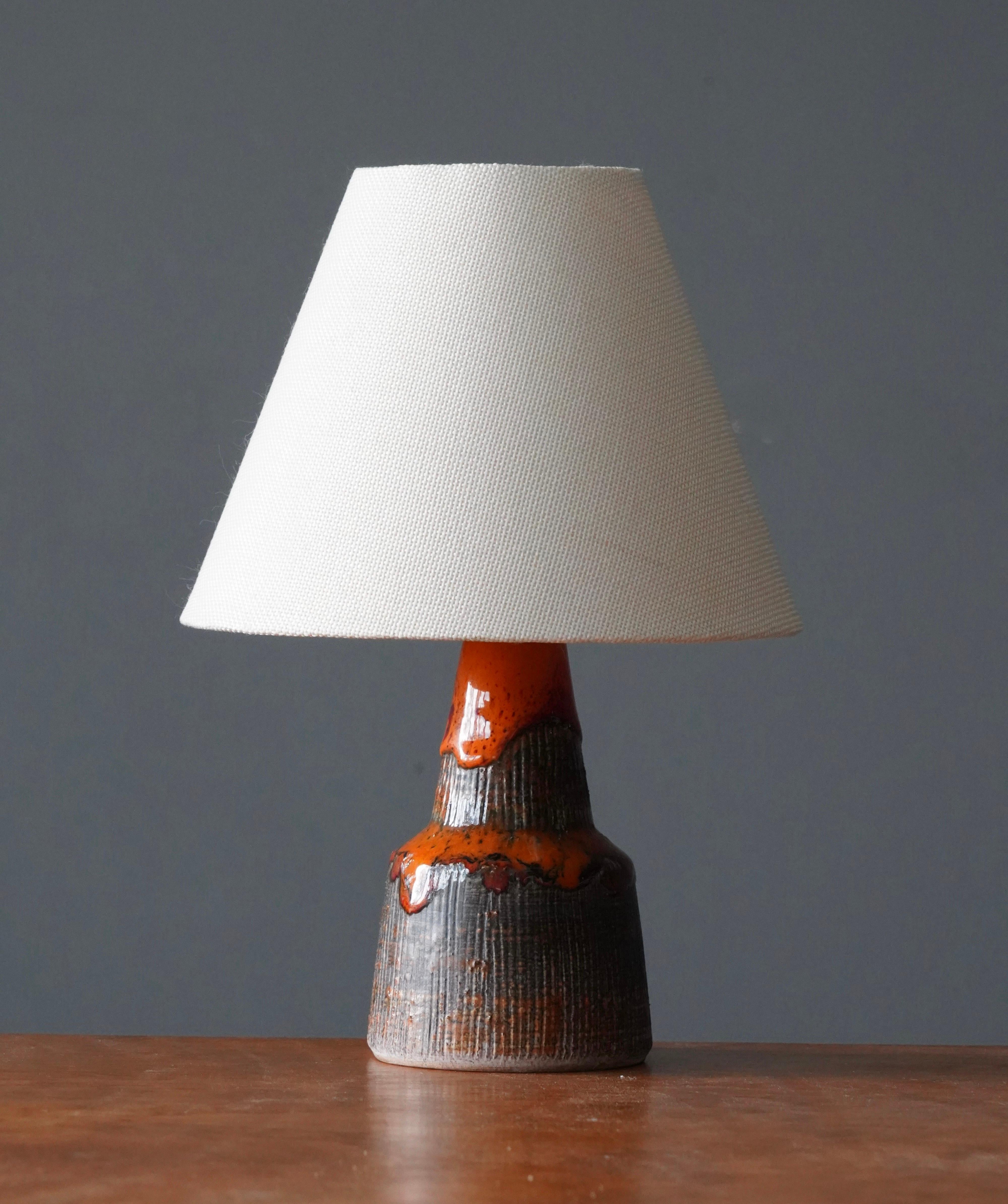A glazed stoneware table lamp. By Tilgmans Keramik, 1950s. Features a complex glaze combined with incised decor in a style iconic to the producer. Features brown, orange and red tones.

Dimensions listed are without lampshade. Height includes