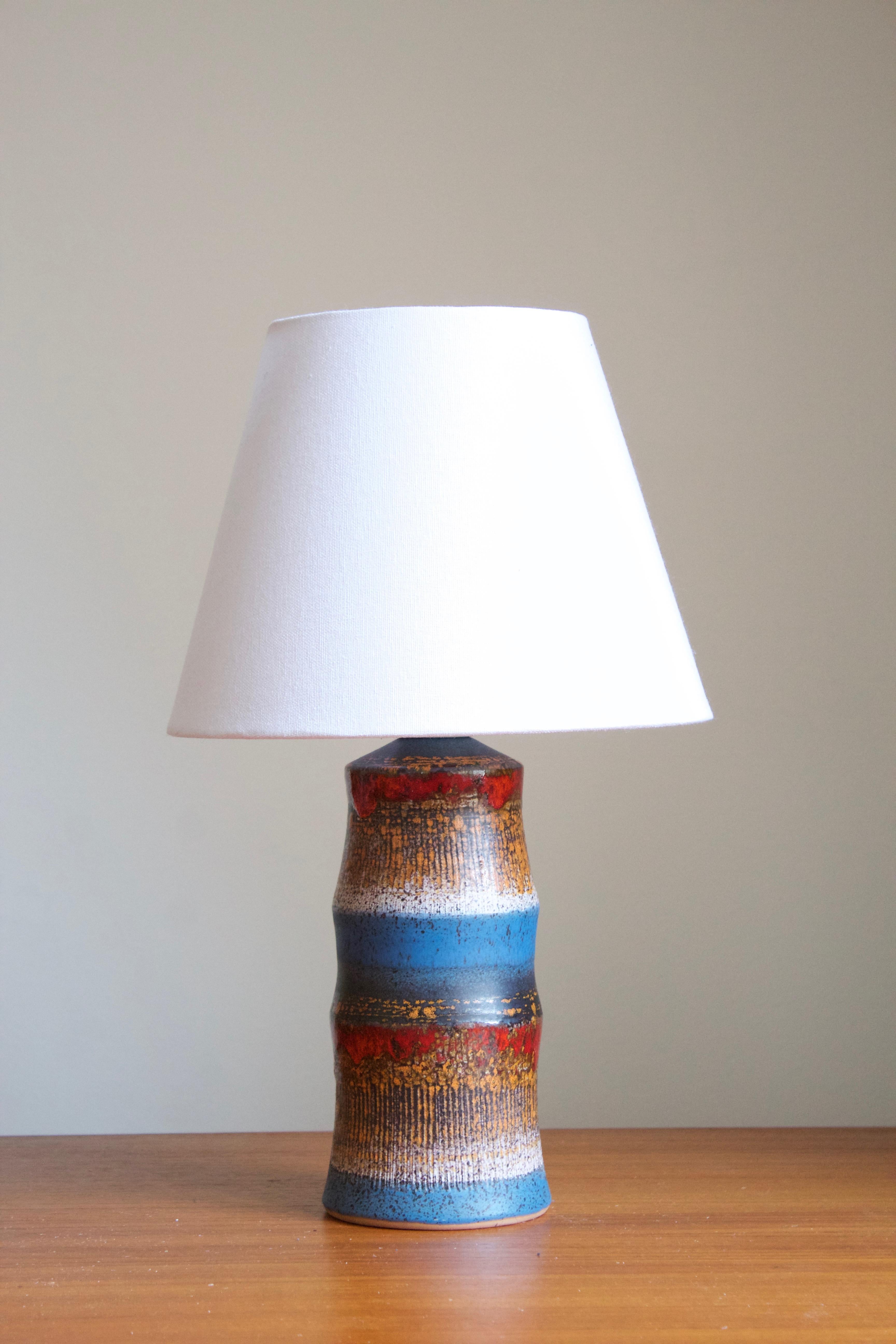 A glazed stoneware table lamp. By Tilgmans Keramik, 1950s. Stamped. Sold without lampshade.

Glaze features brown-blue-red-white-orange colors.

Other designers of the period include Gunnar Nylund, Axel Salto, Arne Bang, and Carl-Harry Stålhane.