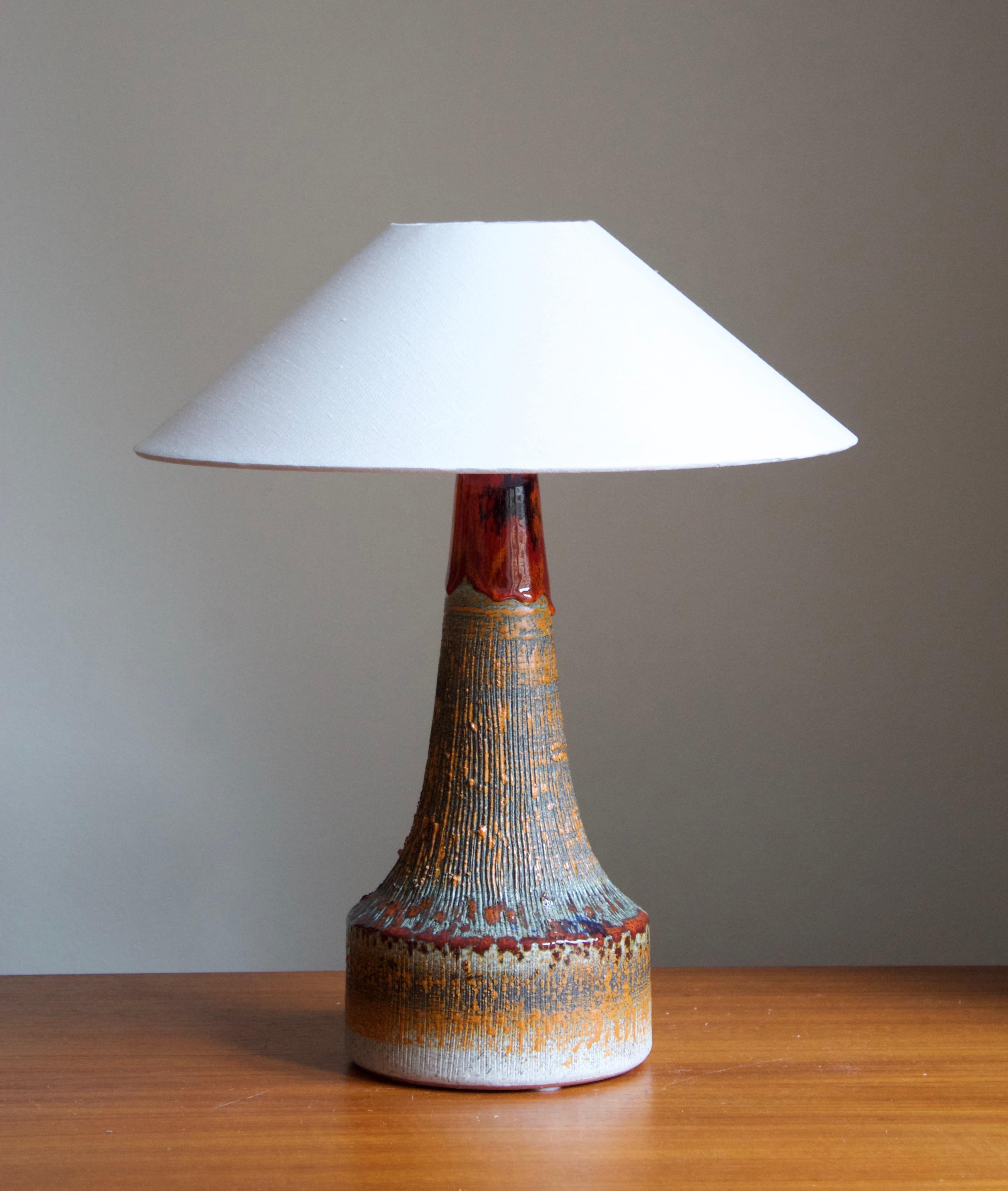 A sizable glazed stoneware table lamp. By Tilgmans Keramik, 1950s. Features a complex glaze combined with incised decor in a style iconic to the producer.

Stated dimensions exclude lampshade. Height includes socket. Sold without lampshade.

Glaze
