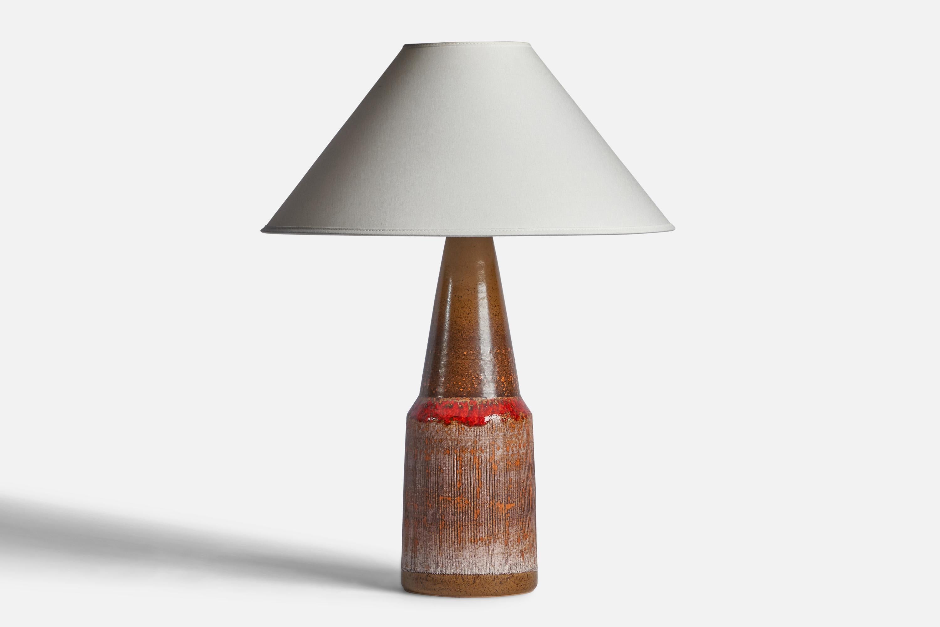 A red and brown-glazed stoneware table lamp designed and produced by Tilgmans Keramik, Sweden, 1960s.

Dimensions of Lamp (inches): 16.5” H x 5.2” Diameter
Dimensions of Shade (inches): 4.5” Top Diameter x 16” Bottom Diameter x 7.25” H
Dimensions of