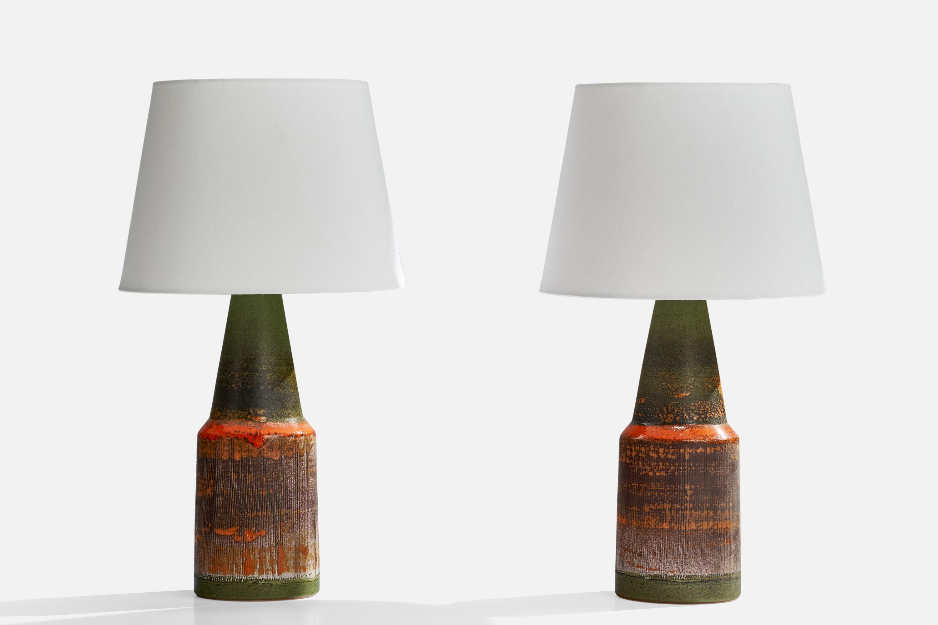 A pair of green and orange-glazed ceramic table lamps designed and produced by Tilgmans Keramik, Sweden, 1960s.

Dimensions of Lamp (inches): 16.5” H x 5”  Diameter
Dimensions of Shade (inches): 9” Top Diameter x 12”  Bottom Diameter x 9”