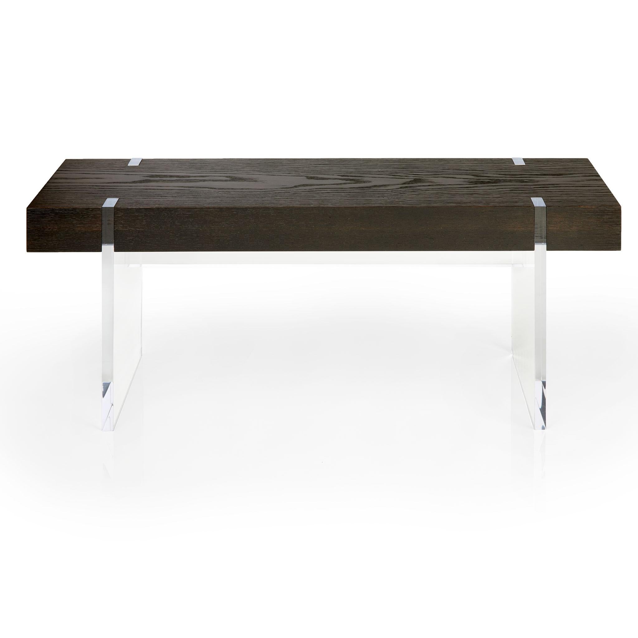 The elegant Tillikum bench features a rare solid wood top set on clear acrylic frame and legs for an airy, floating effect. The minimalist design by Kirk Van Ludwig combines these elements to create a modern entrance bench. The Torched Oak uses a
