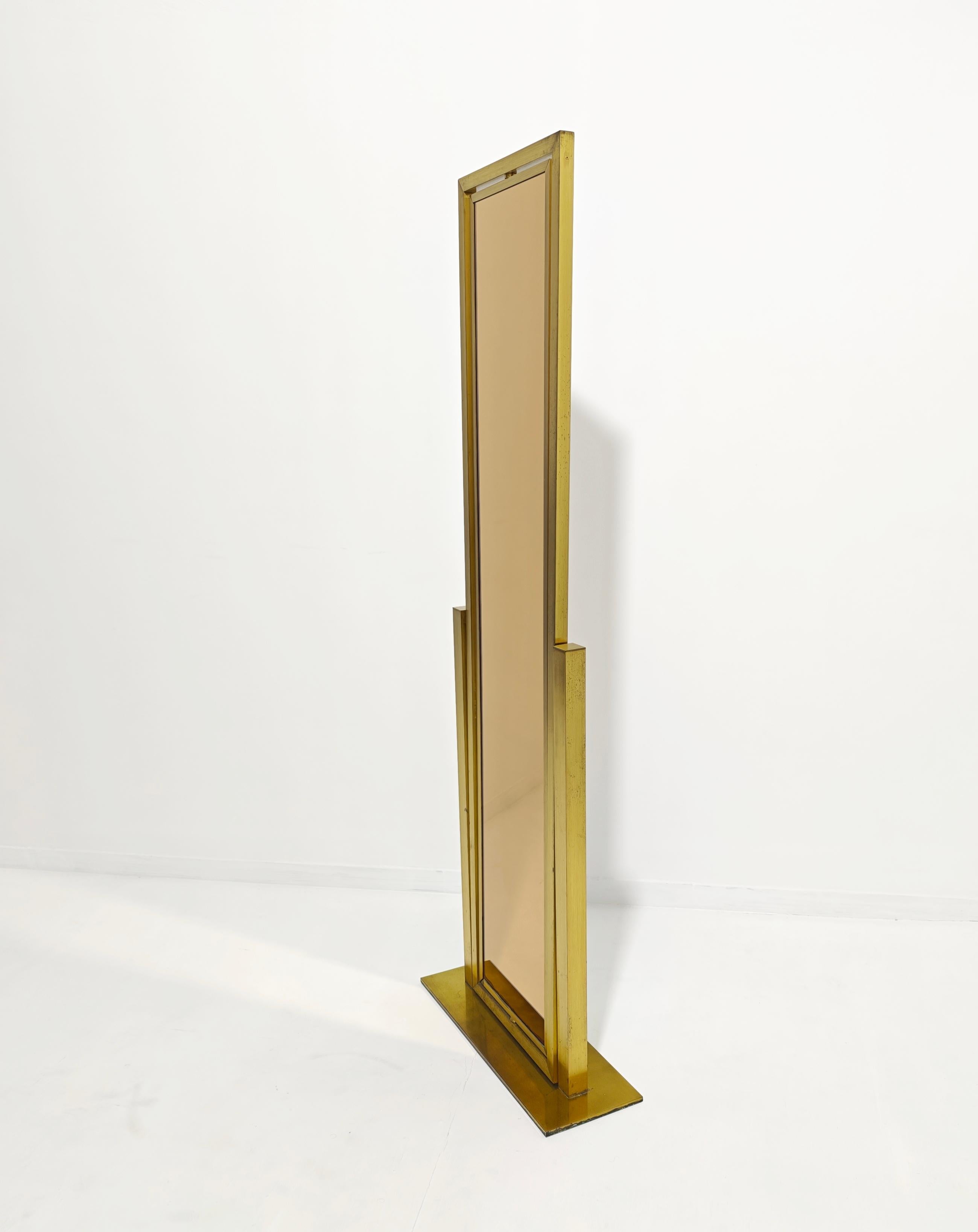 Rare in its kind. Tiltable and adjustable floor mirror. Functionality at its best. Another special feature is the double glass mirror, white on one side and caramel on the other. Structure in brass and brushed aluminum. Thanks to its shape it can be