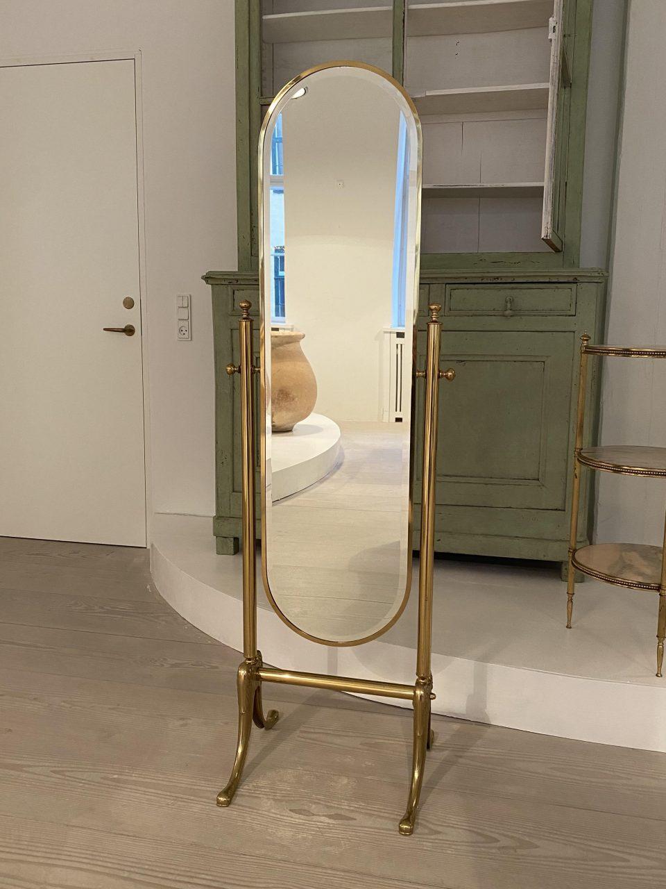 Elegant old French figure mirror, with a charming narrow elongated tilting mirror. The dressing mirror is made of brass with a beautifully designed base, in the Empire style and with its original faceted oval mirror glass.

Suitable mirrorfor the