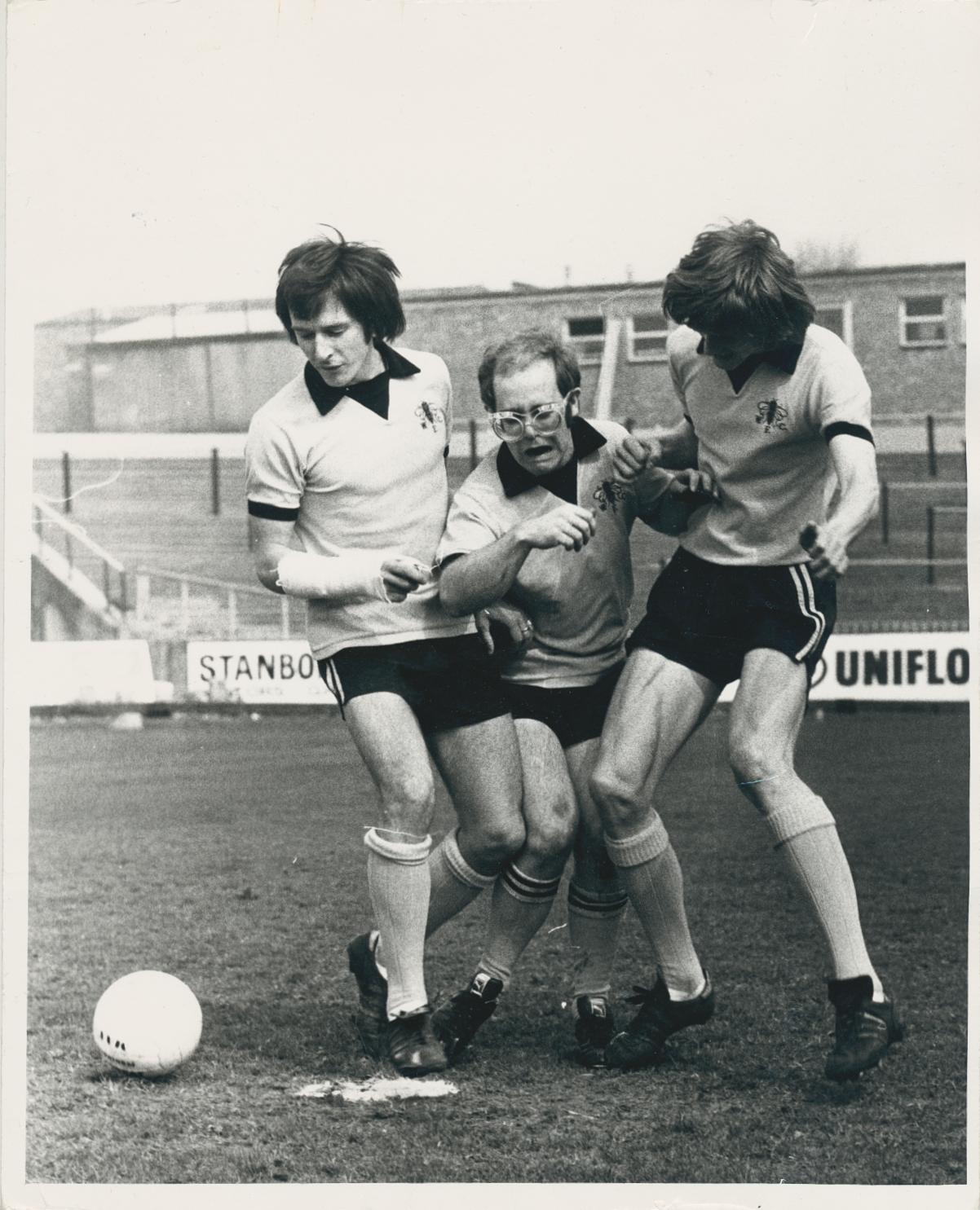 Tim Graham Black and White Photograph - Elton John in a soccer match, Watford FC Shirts, 1973