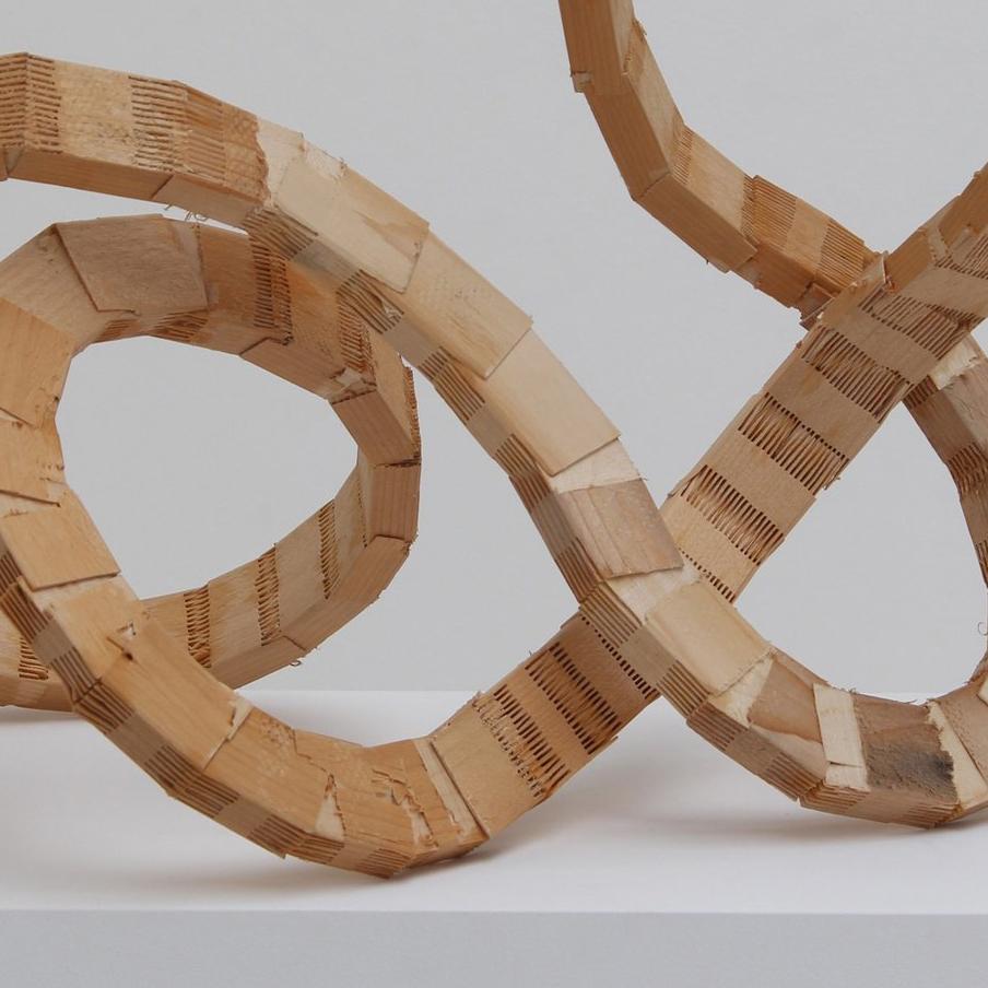 The shape of a rubber band is made by cutting an 8-foot long board into small pieces, then joining them with hand-carved tongue and groove.

Medium: wood and super glue
