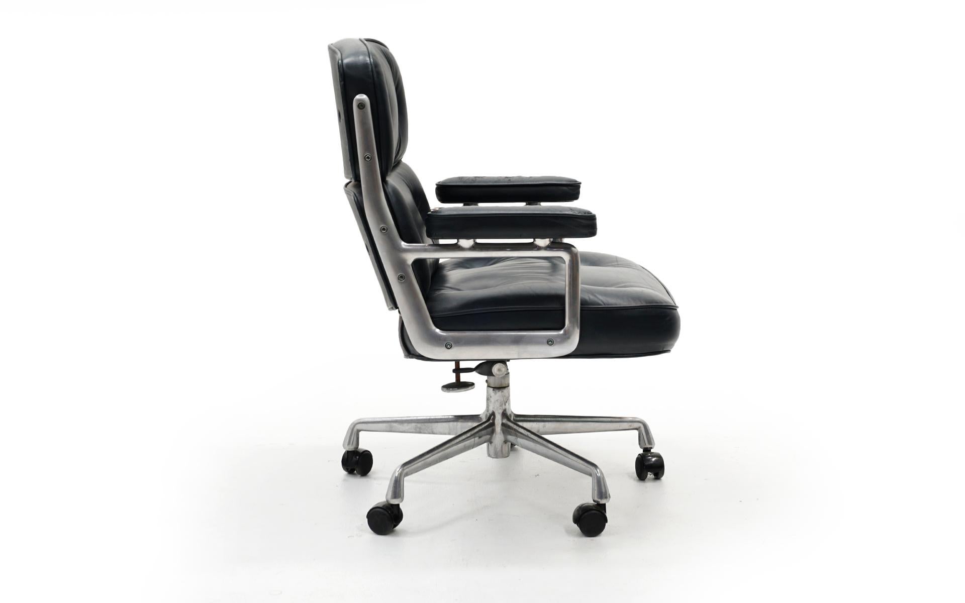 Eames time life chair is dark blue grey leather and cast aluminum frame. Five prong base. 1980s original Herman Miller production. See photos for wear on one arm which does not interfere with function or the overall beauty of this chair in this rare