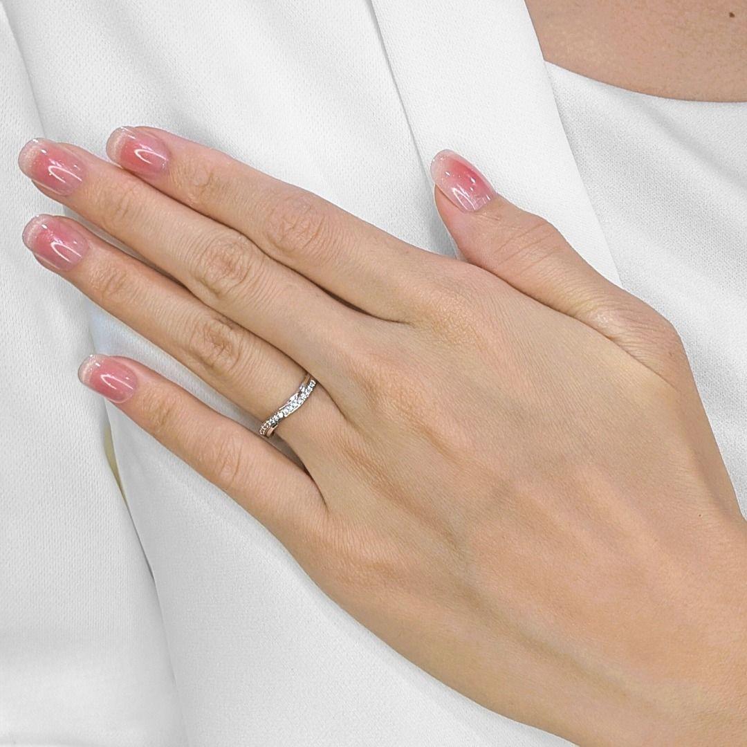 A fusion of artistry and refinement, this sophisticated 18K white gold ring showcases an exquisite band design, accentuated by 16 natural diamonds totaling 0.11ct. The round brilliant-cut diamonds, carefully selected for their G-H color and VS