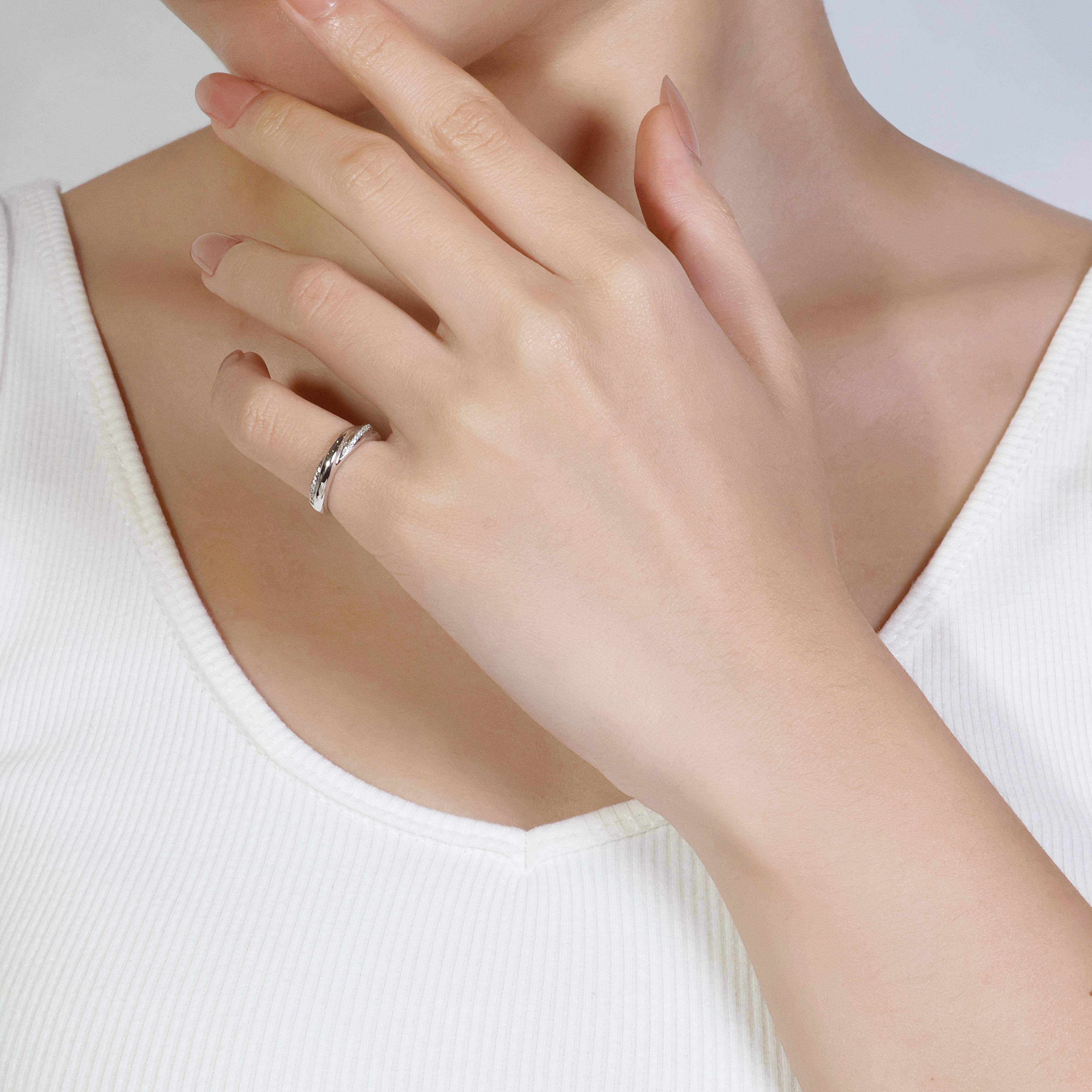 This elegant 18K White Gold ring is adorned with 15 round brilliant diamonds, totaling 0.06 carats in weight. The diamonds are graded G for color and VS for clarity, offering a beautiful sparkle and high quality. With a total weight of 3.06 grams,