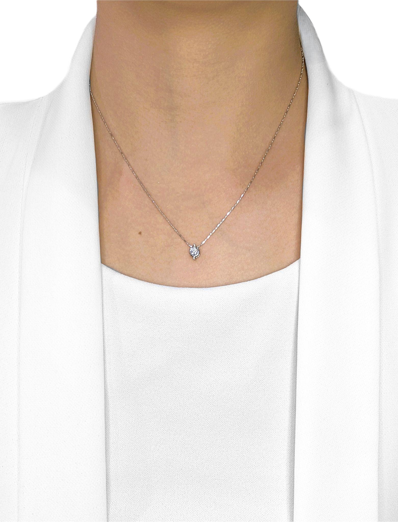 Discret mais radieux, ce pendentif en or blanc 18 carats est orné d'un seul diamant naturel rond et brillant pesant 0,20 carats. De couleur F et de pureté VS, le diamant présente une brillance et un feu exceptionnels, magnifiquement mis en valeur