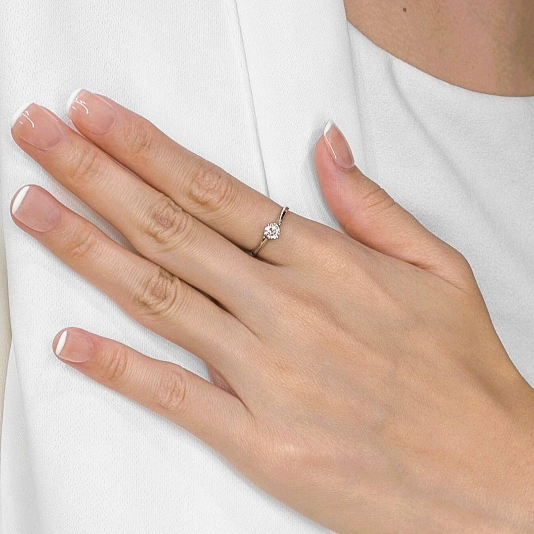 Entdecken Sie den unvergleichlichen Glanz dieses exquisiten, neuen und ungetragenen Solitärrings von SOOKEE BRILLIANT ROSE (BR 18617), der sorgfältig aus strahlendem 18 Karat Weißgold gefertigt ist. In seinem Herzen glänzt ein prächtiger runder