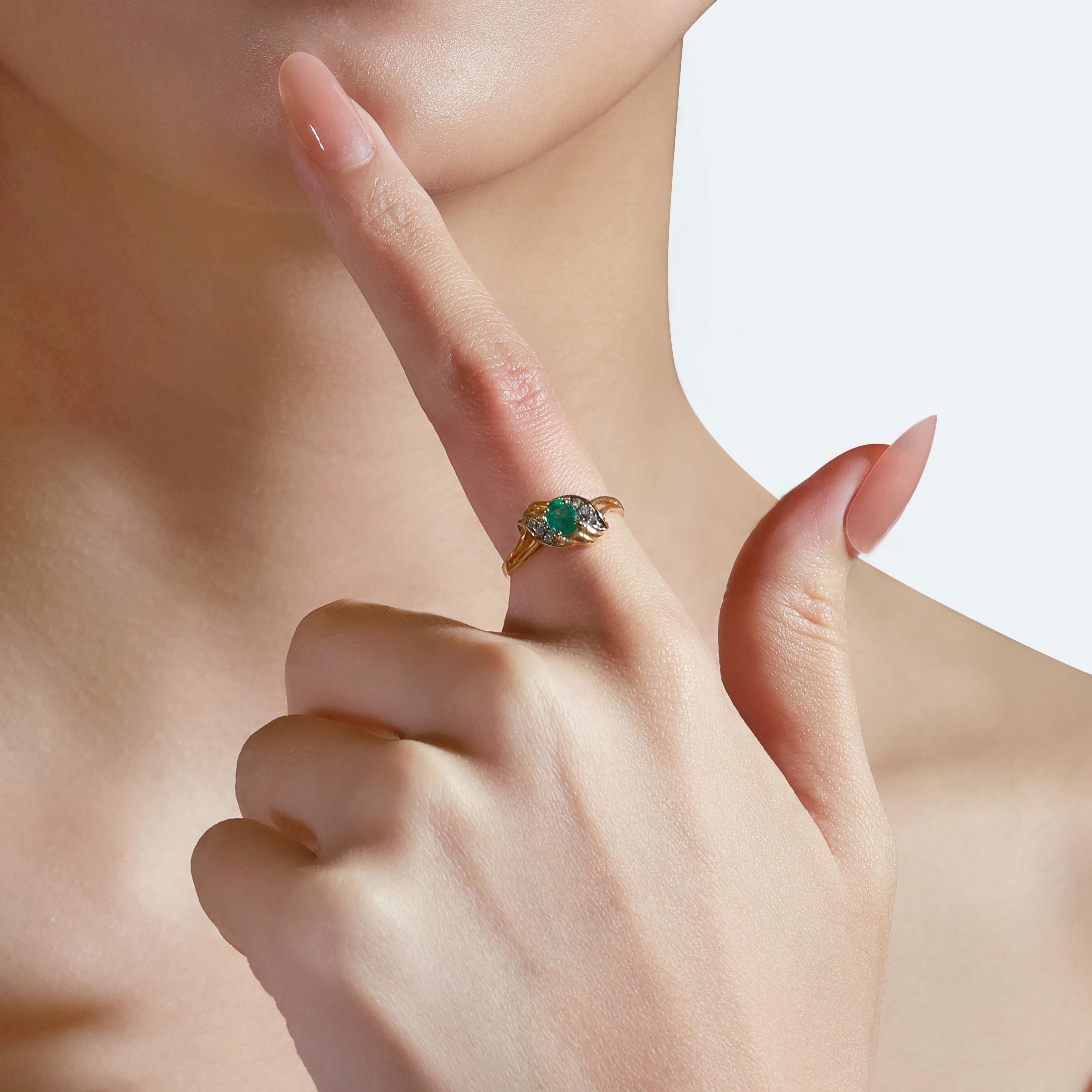 This elegant 18K yellow gold ring features a 0.45-carat oval emerald, exuding a rich green hue. The piece is further enhanced with 6 round brilliant-cut diamonds totaling 0.05 ct, adding a touch of sparkle. The total carat weight of 0.50 ct and the