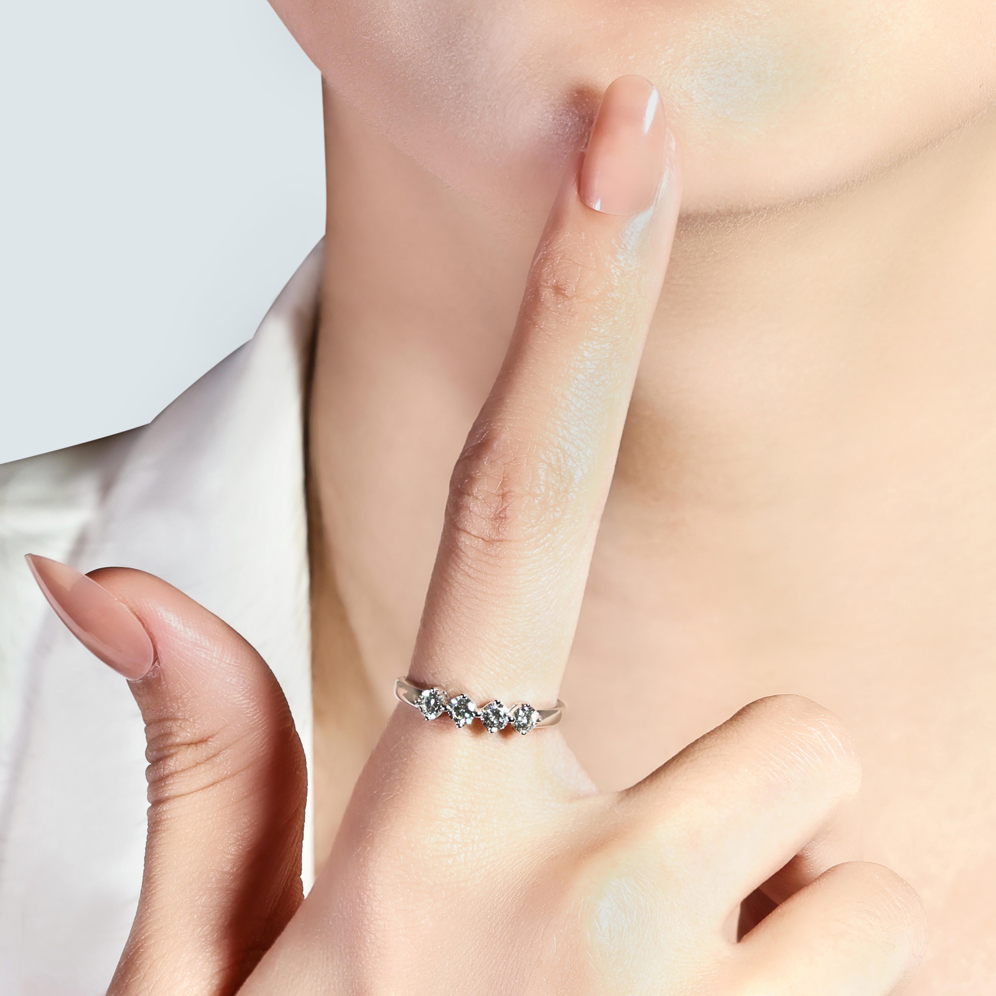Lassen Sie sich von der zeitlosen Eleganz dieses exquisiten Rings aus 18 Karat Weißgold verzaubern, dessen Hauptsteine aus vier atemberaubenden runden Brillanten bestehen. Mit einem Gesamtkaratgewicht von 0,6 Karat sind diese Diamanten mit J für die