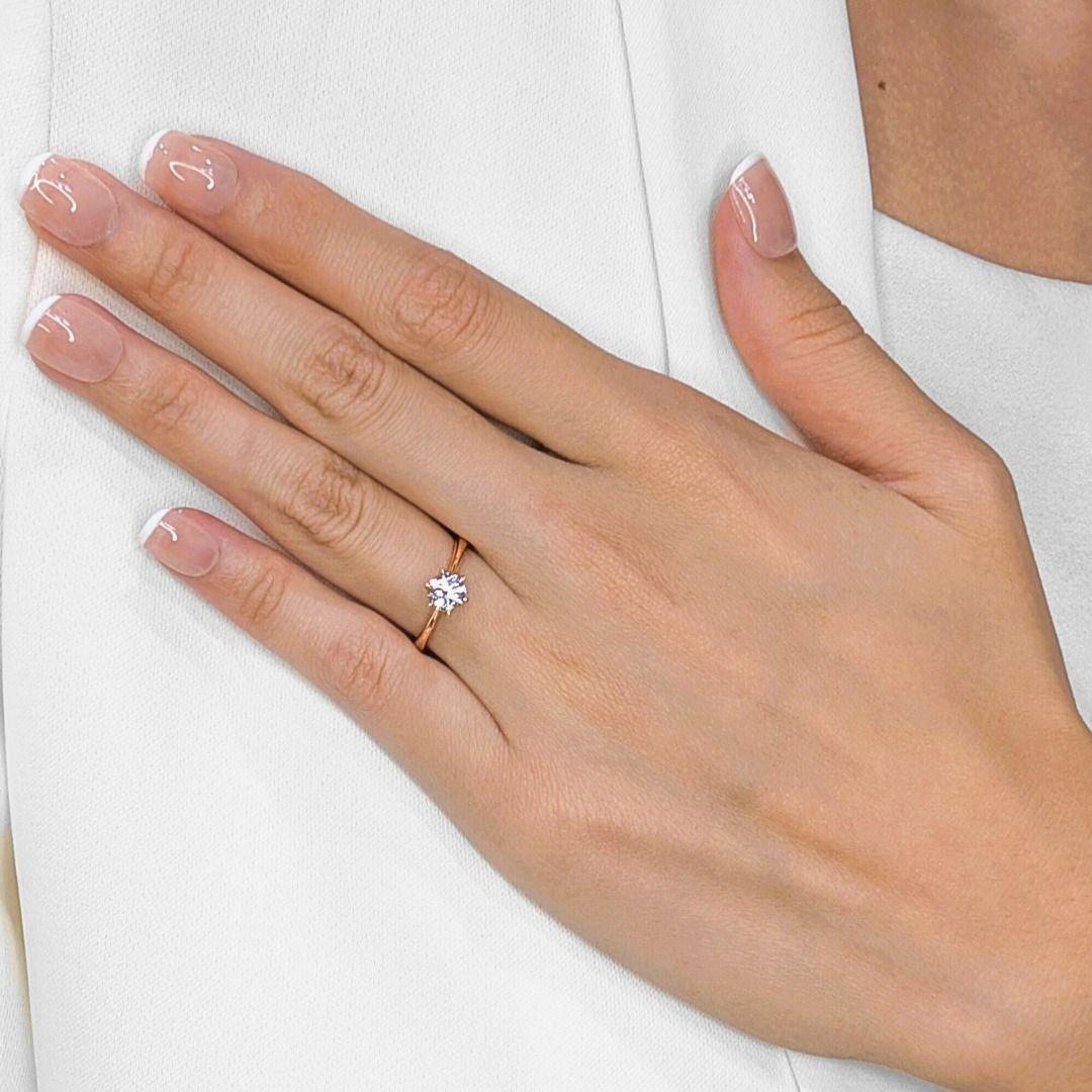 This sophisticated pre-owned Destinee Lee Hwa ring exudes timeless elegance with its sleek 18K rose gold setting, featuring a 0.70ct round brilliant diamond of exceptional E color and VS1 clarity that sparkles with crisp brilliance from every angle.