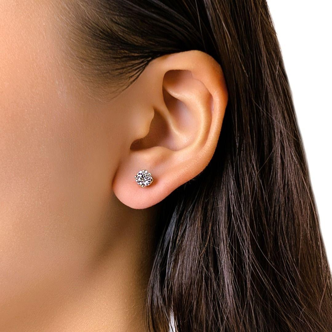 Ces boucles d'oreilles classiques sont ornées de deux diamants ronds et brillants d'une valeur totale de 1,22 carat, tous deux de couleur G et de pureté SI1 et SI2, et certifiés par le GIA. Serti dans un or jaune 18 carats chaleureux, le design à