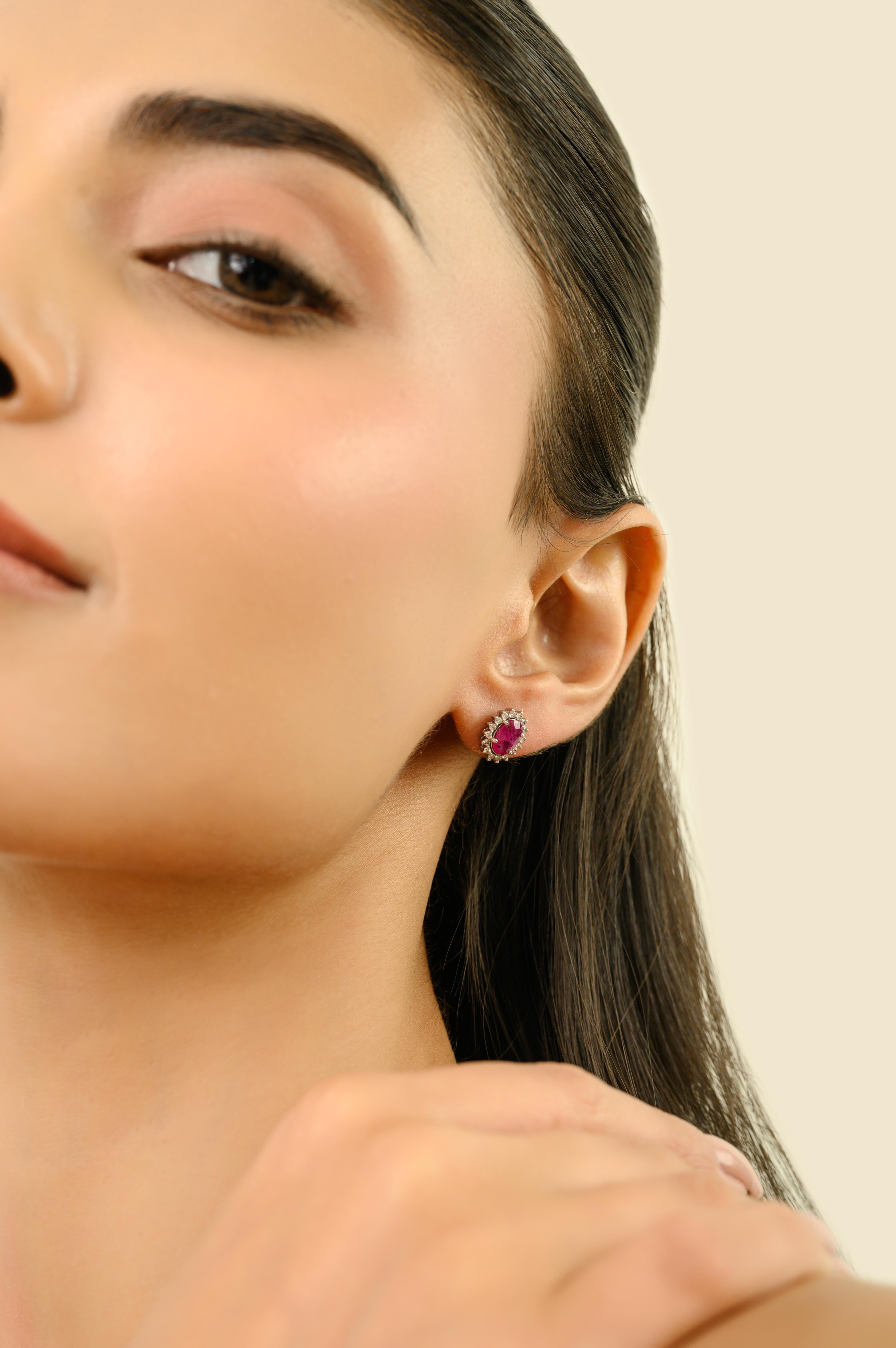 Timeless 1.45 Carat Oval Cut Ruby & Diamond Halo Stud Earrings in 18K White Gold In New Condition For Sale In New York, NY