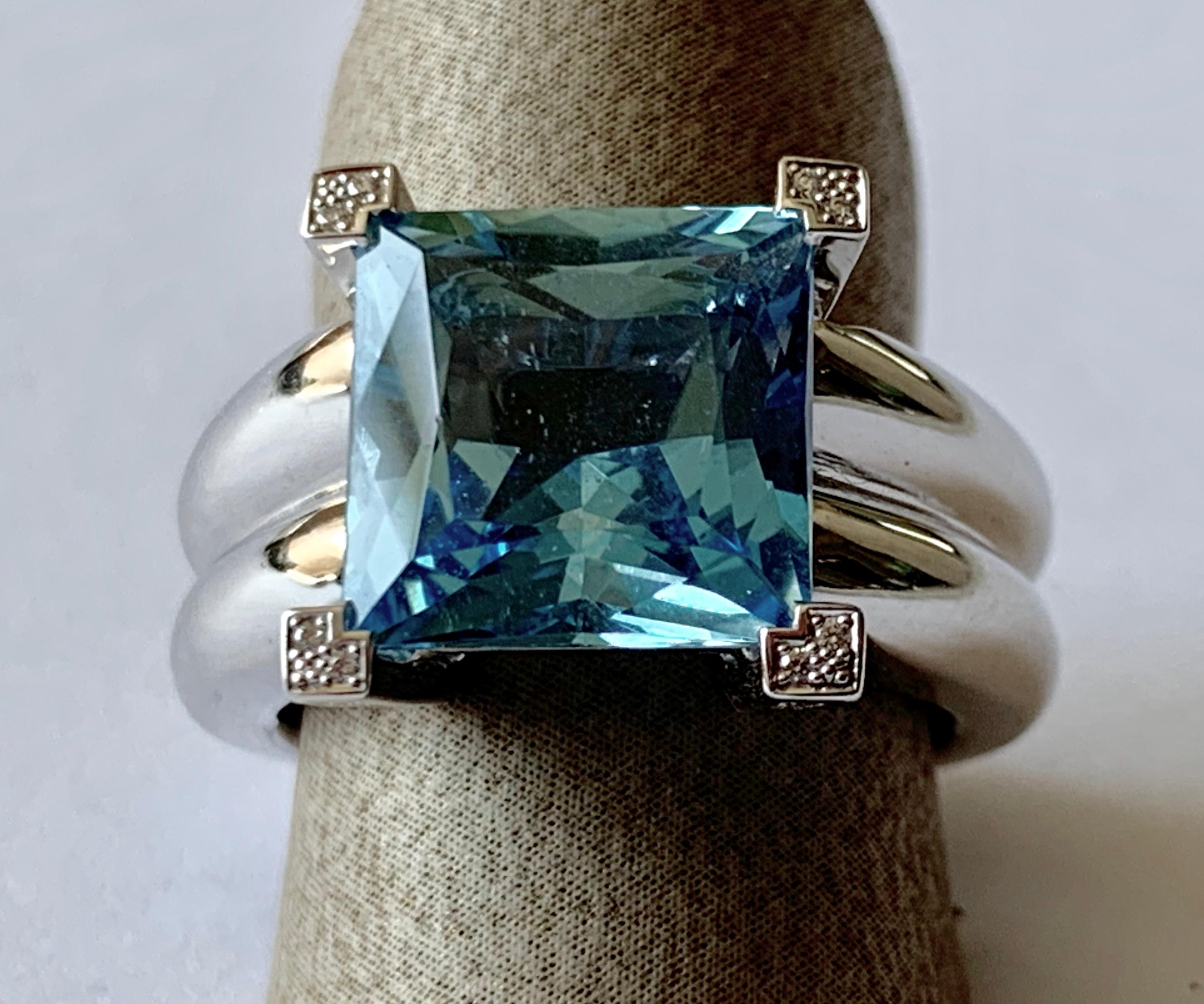 Solid White gold 750. Casual-elegant band ring, the top set with 1 fine square cut aquamarine of 5.42 ct  the 4 prongs are set with numerous small brilliant-cut diamonds totalling 0.21 ct. Size 55. 