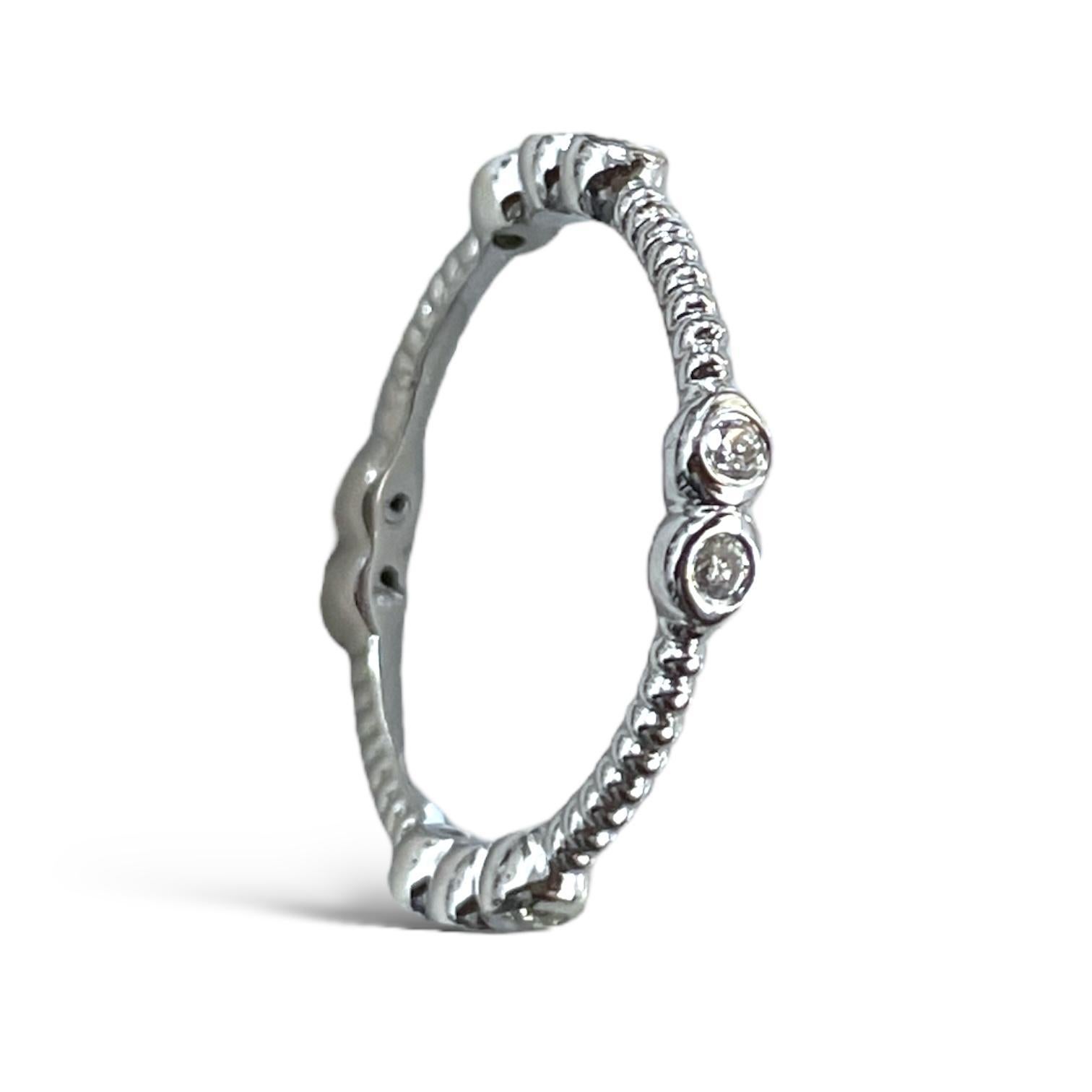 Cette exquise bague en or blanc 18 carats présente un magnifique design perlé, rehaussé par des diamants de taille ronde sertis dans un arrangement captivant. Son style à la fois délicat et luxueux est parfait pour ajouter un éclat subtil à