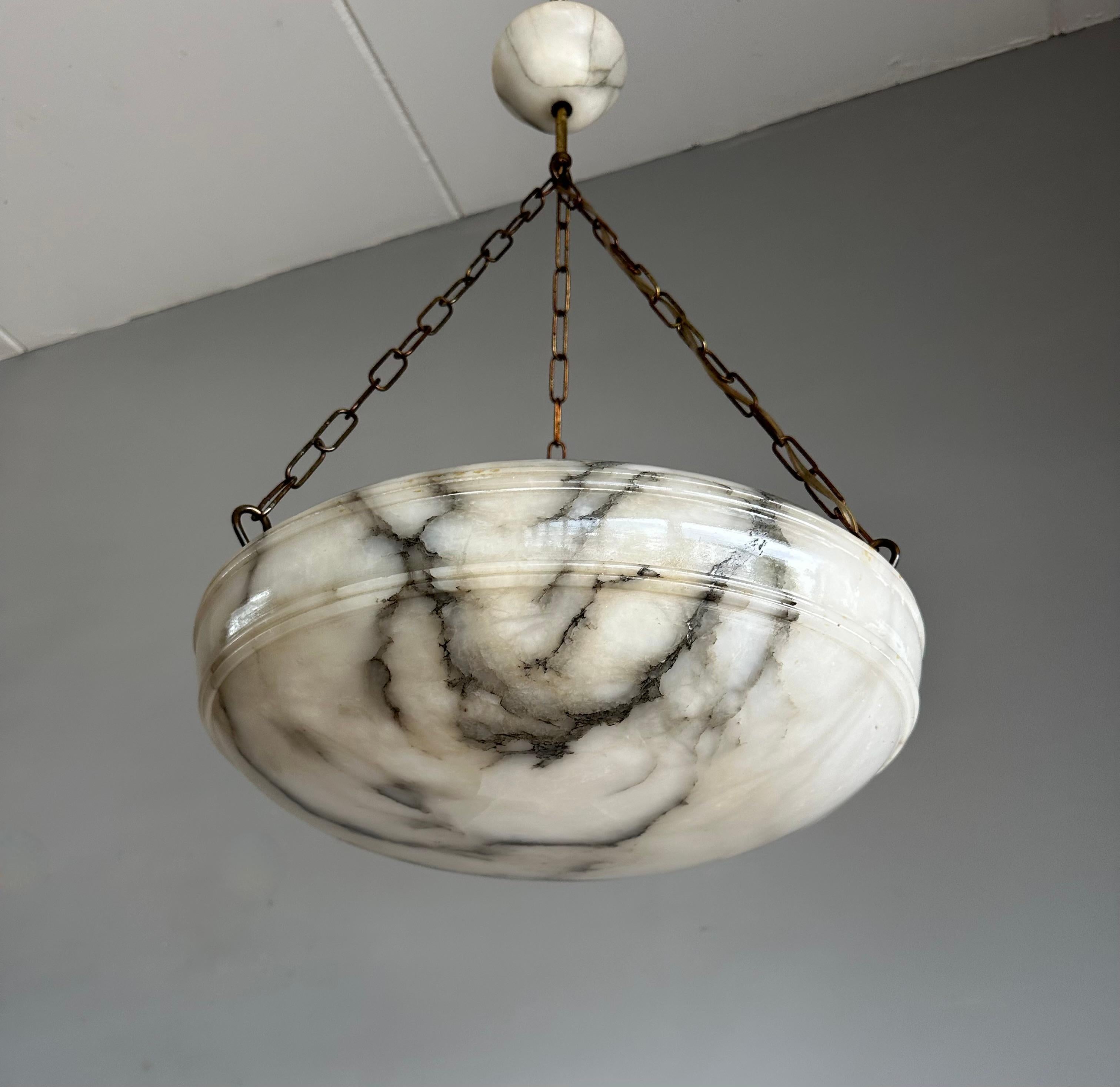 One of a kind light fixture with a stunning “ flameboyant black and white “ alabaster disc-shade.

Thanks to its timeless design, its large size and its good condition this alabaster chandelier will light up both your days and evenings, both in