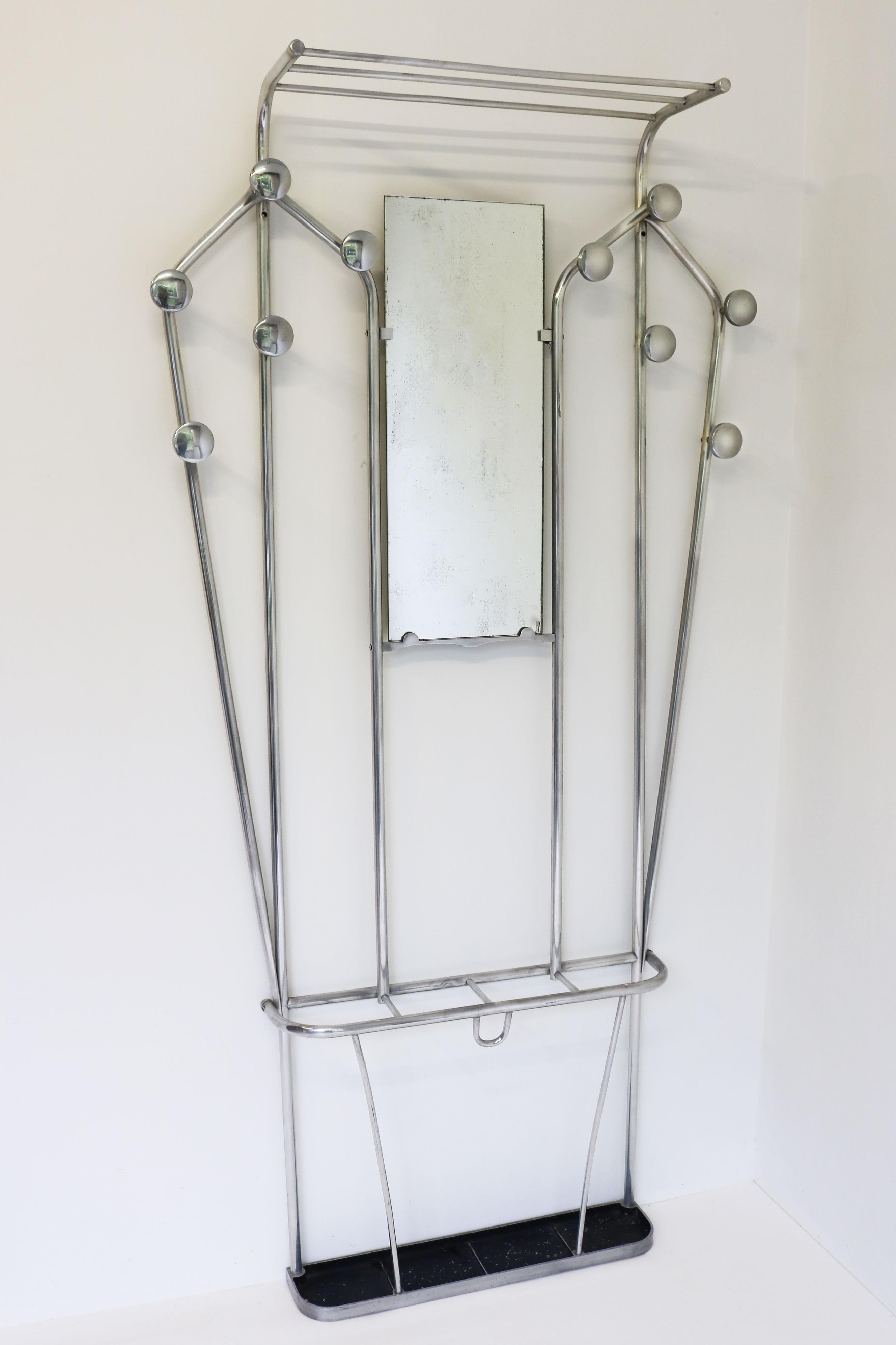This Art Deco style hall tree hails from France, circa 1930s. It is crafted out of sleek, polish aluminium and functions as an umbrella stand, hat shelf, and coat rack. There is even a mirror in the centre, making this piece perfect for any