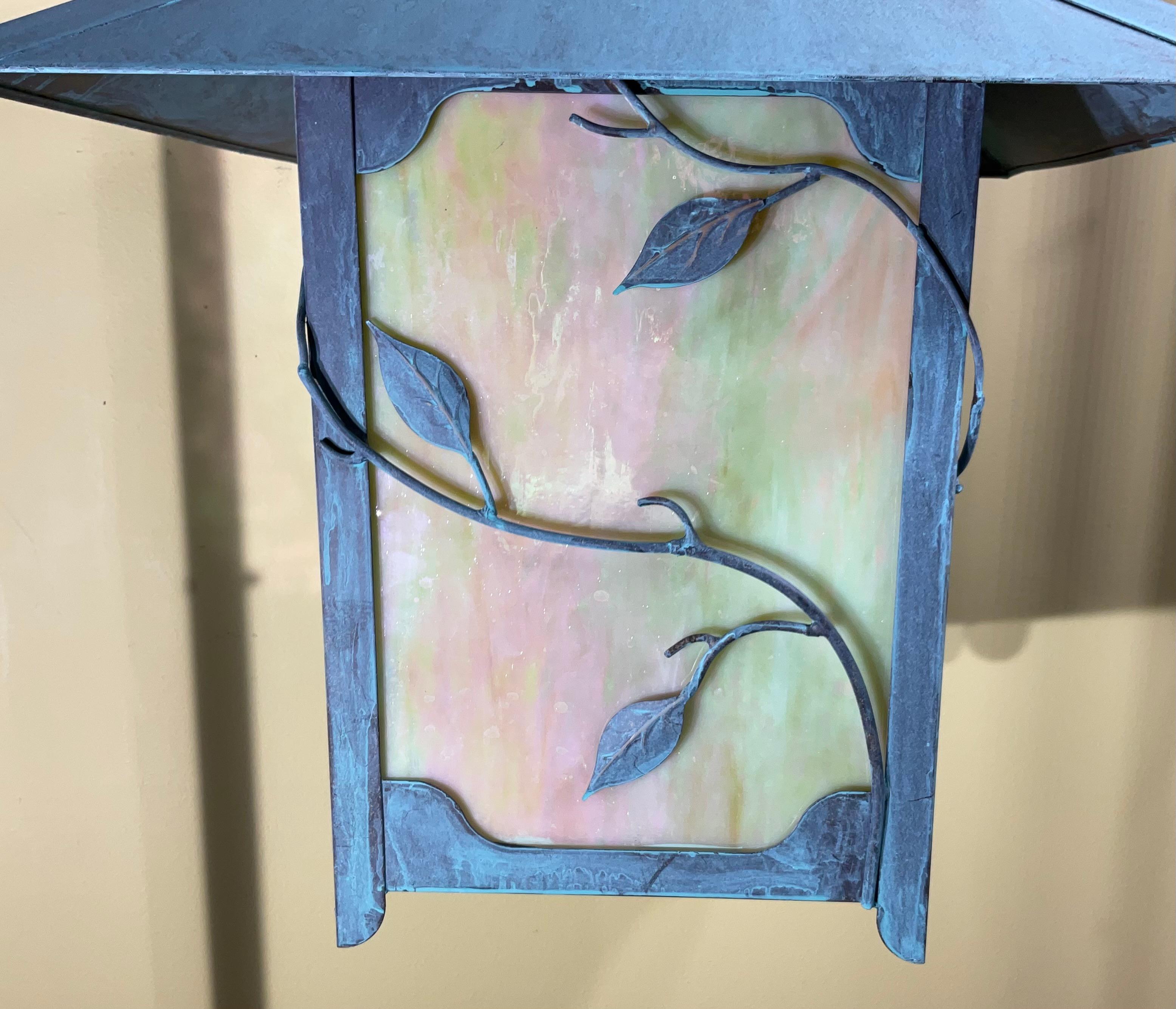 Diese exquisite Laterne ist ein wahres Kunstwerk, das die Eleganz von massivem Messing mit der fesselnden Schönheit von Kunstglas verbindet. Das filigrane Design und die reiche Patina schaffen ein warmes und einladendes Ambiente, das sich perfekt