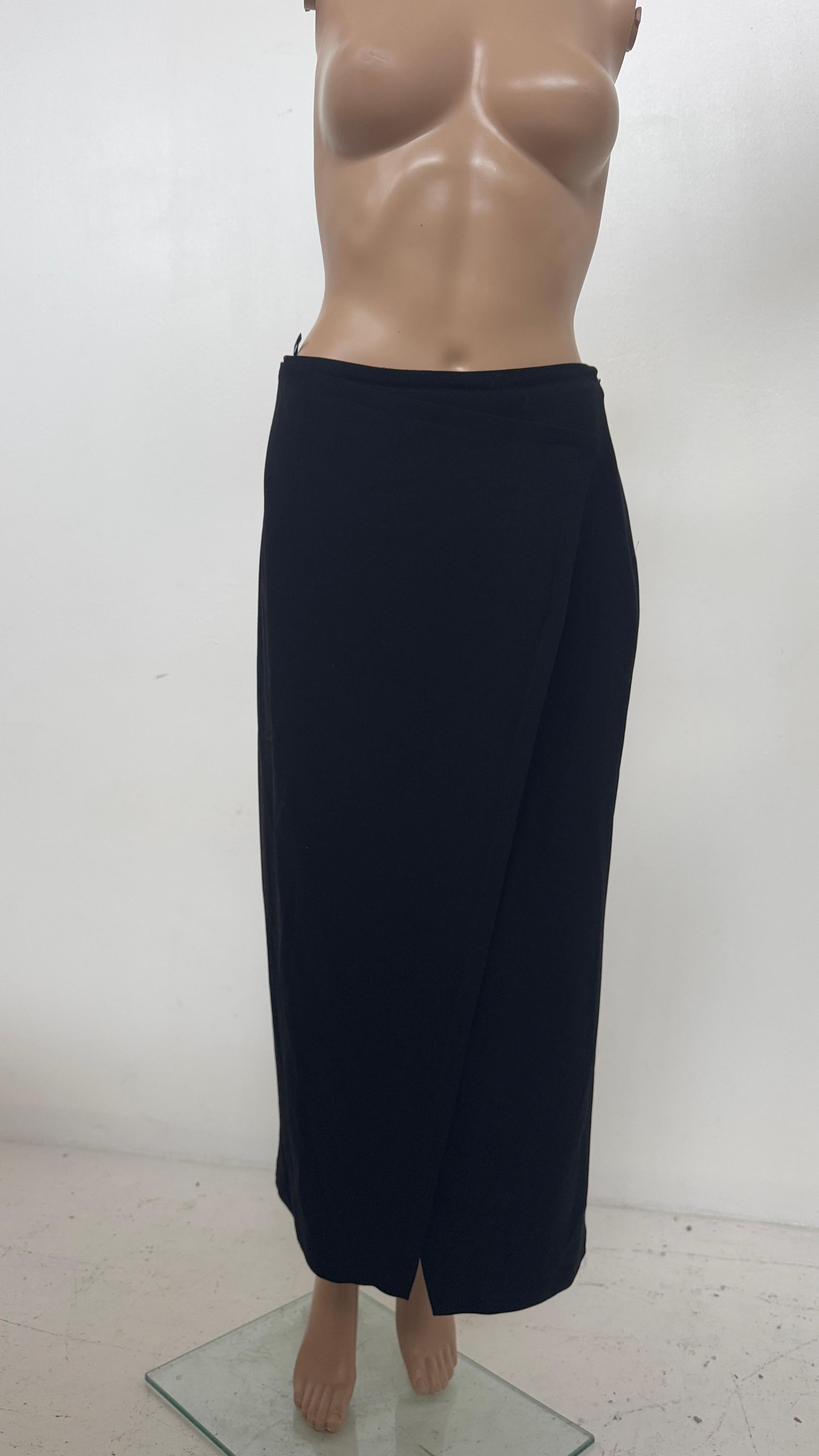 Elegant and refined, this minimalist black pencil skirt from the prestigious Calvin Klein Collection is a true staple of timeless luxury. Expertly crafted in Italy, the skirt features a sleek, wrap-inspired front slit that adds a subtle