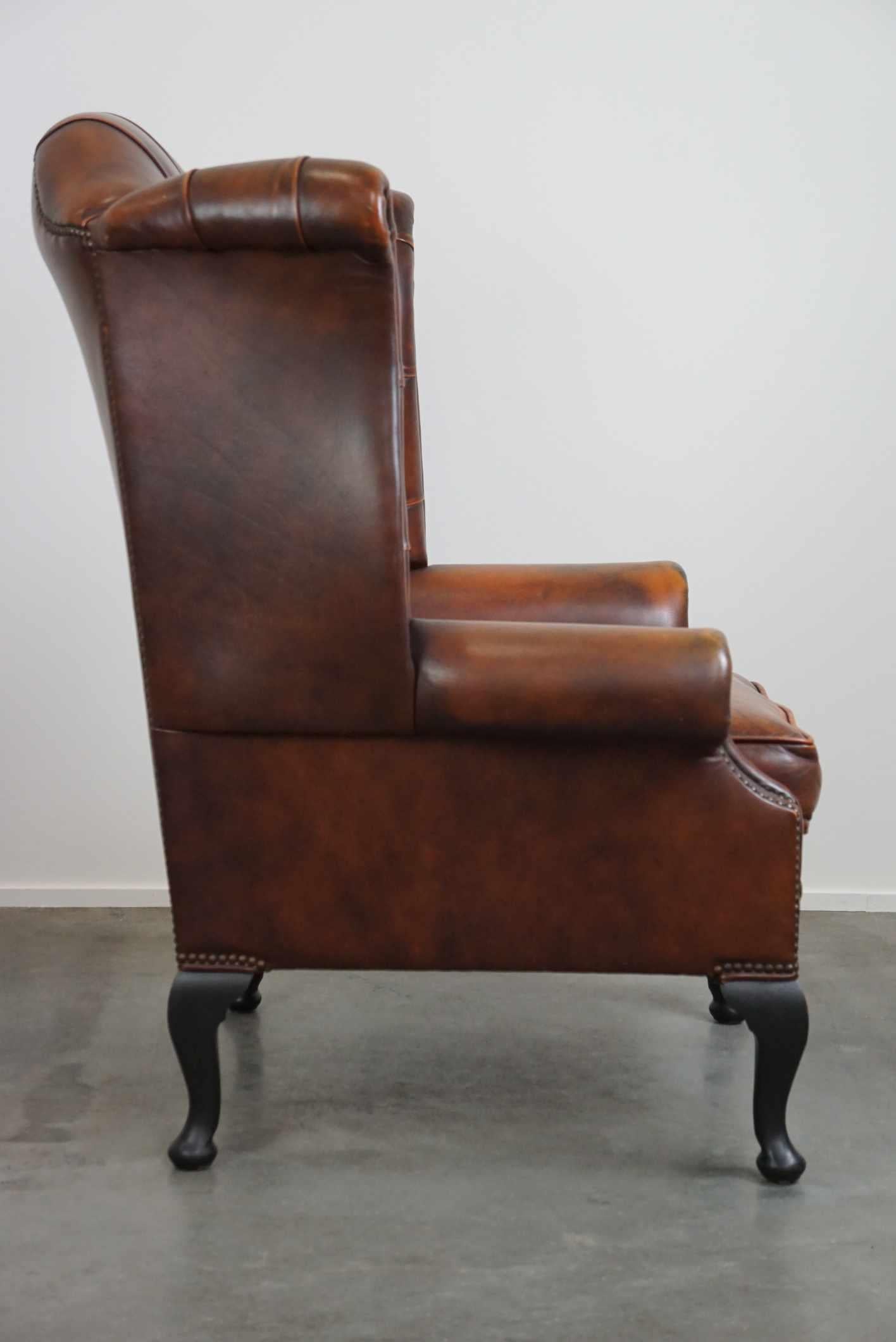 Hand-Crafted Timeless cognac-colored English cowhide Chesterfield wingback armchair in good c For Sale
