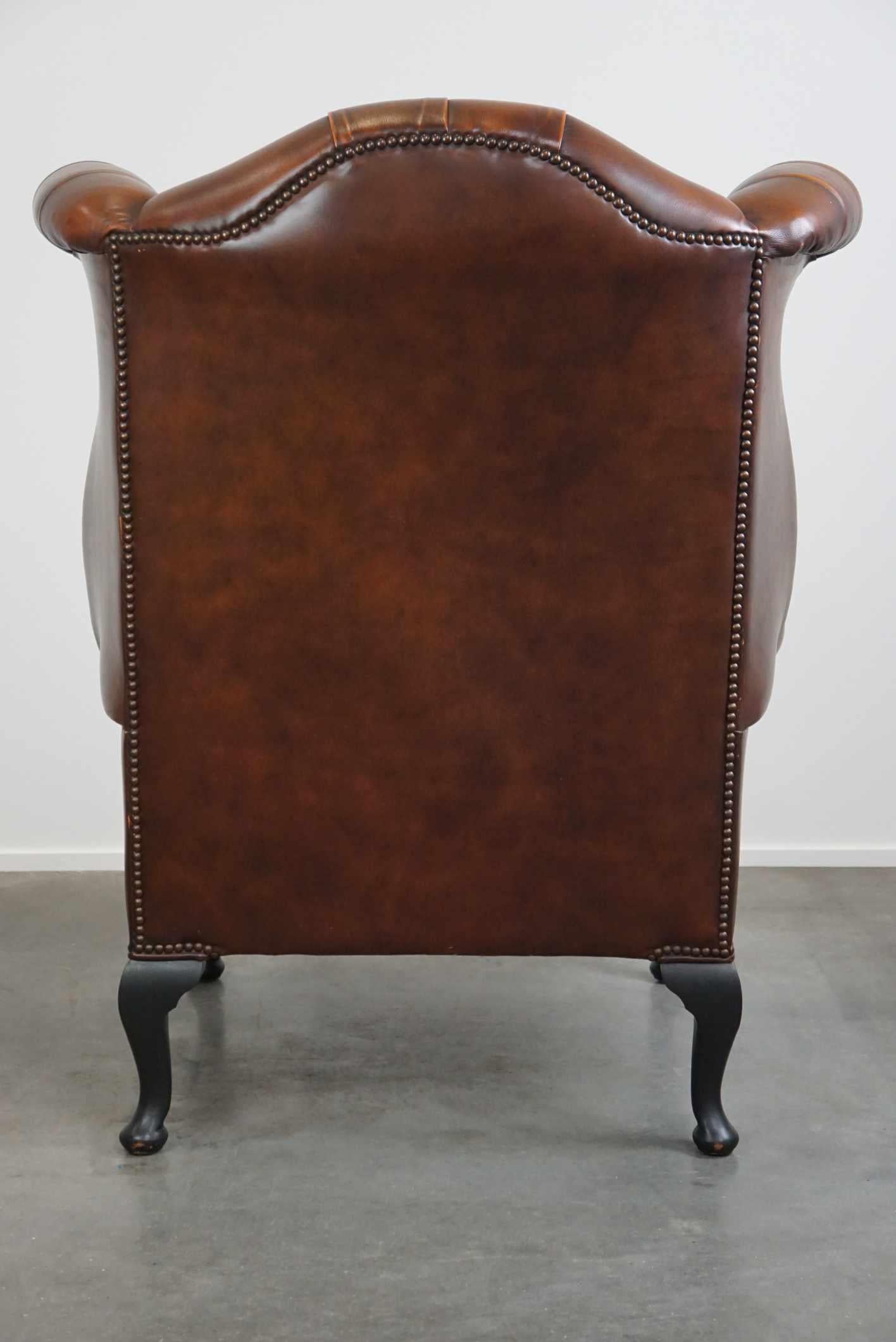 Hand-Crafted Timeless cognac-colored English cowhide Chesterfield wingback armchair in good c For Sale
