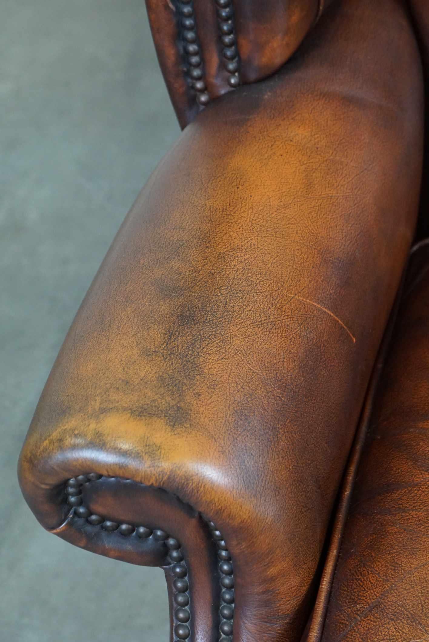 Timeless cognac-colored English cowhide Chesterfield wingback armchair in good c For Sale 1