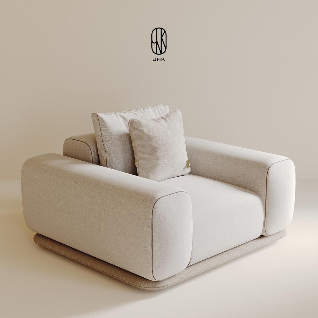 Fauteuil Stride, 

Elle présente un design simple et moderne. Ses lignes larges et douces se distinguent, tapissées de tissu beige clair, offrant une assise confortable. Les accoudoirs et l'assise sont larges et moelleux, mettant l'accent sur le