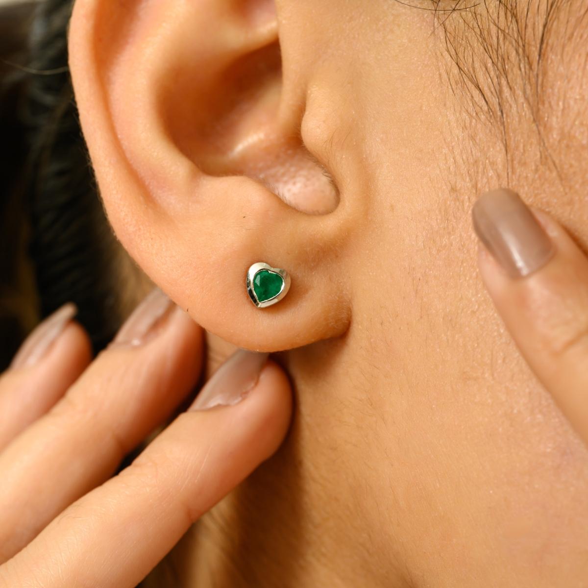 Ajoutez une touche d'élégance intemporelle à votre look avec ces exquises boucles d'oreilles en forme de cœur. Réalisée en or blanc 14k, chaque boucle d'oreille est ornée d'une pierre précieuse d'un vert éclatant, d'un poids total combiné de 0,44