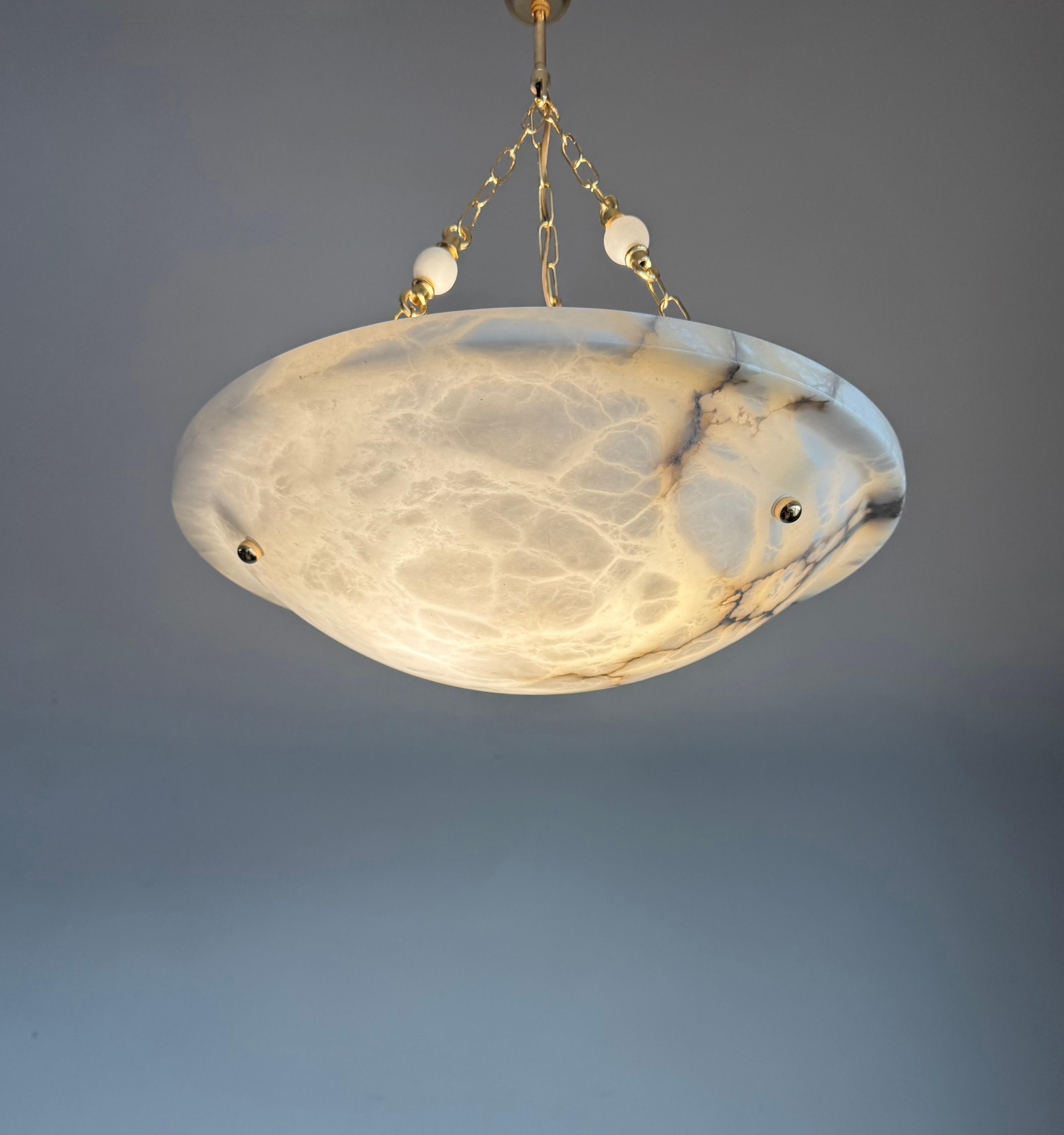Large size (18.9 inches) hand carved, Midcentury Modern alabaster three-light pendant light in mint condition.

Thanks to its 'calm' and timeless Art Deco design this alabaster chandelier will look great in all kinds of interiors. It is in very good