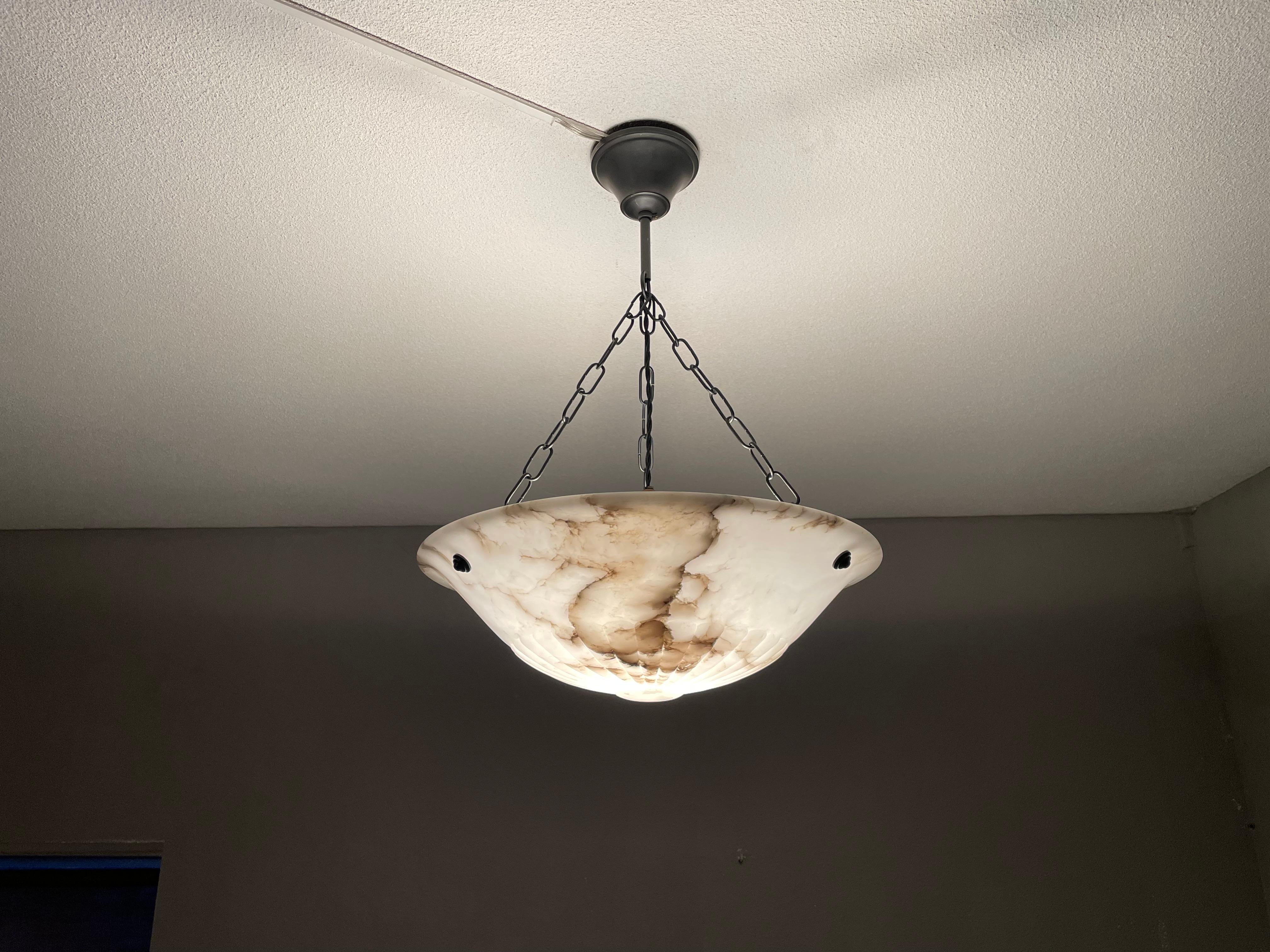 Good size and timeless, hand carved, antique alabaster pendant light.

Thanks to its 'calm' and timeless design this alabaster chandelier will look great in all kinds of interiors. It is in very good condition from top to bottom and the beautifully