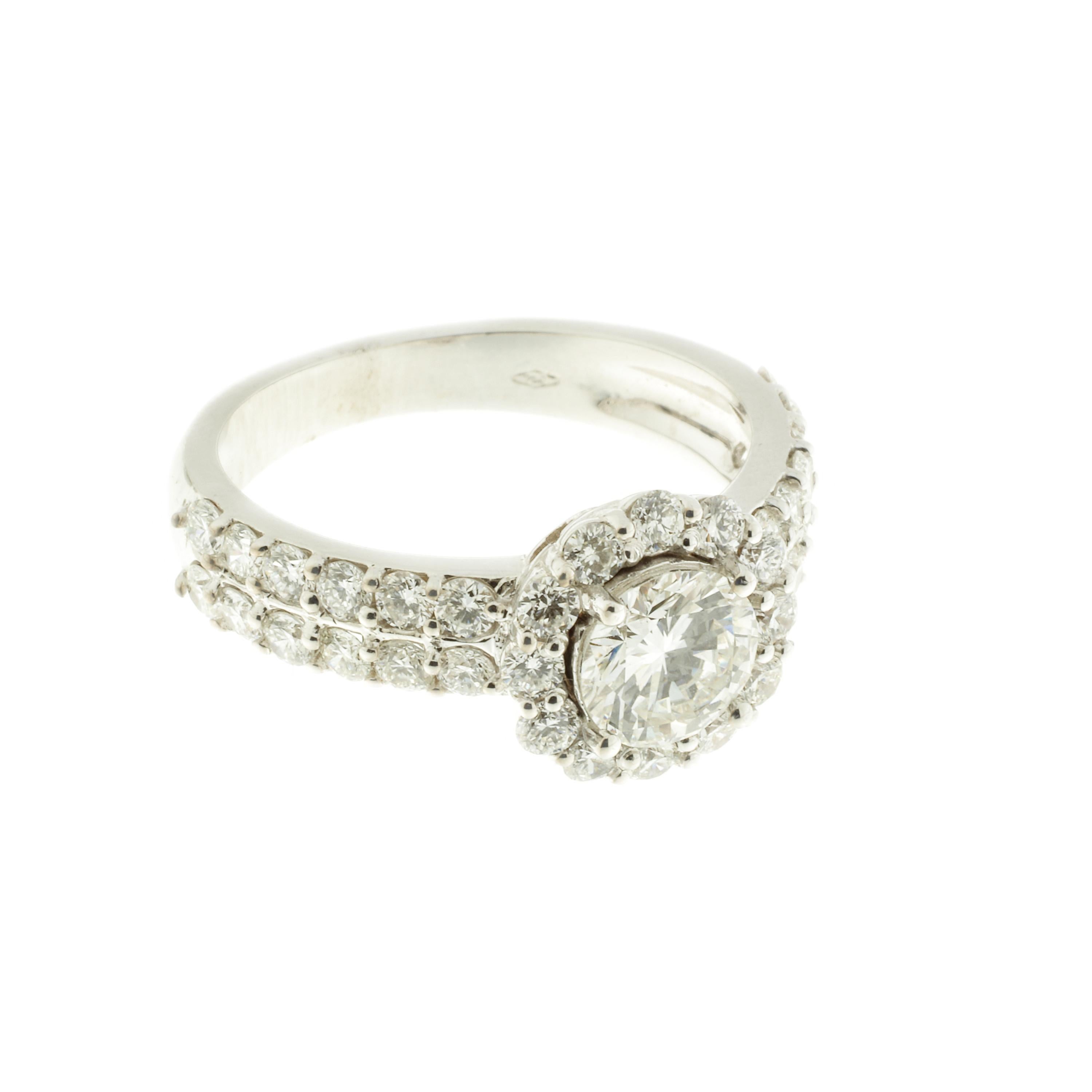 A central brilliant-cut diamond with a halo and a double row of lateral diamonds total 2.17 carats. This knock-out ring is timeless. The central diamond weighs 0.93-carats and all the stones are rated G VS. 

The photographed ring measures 7.25