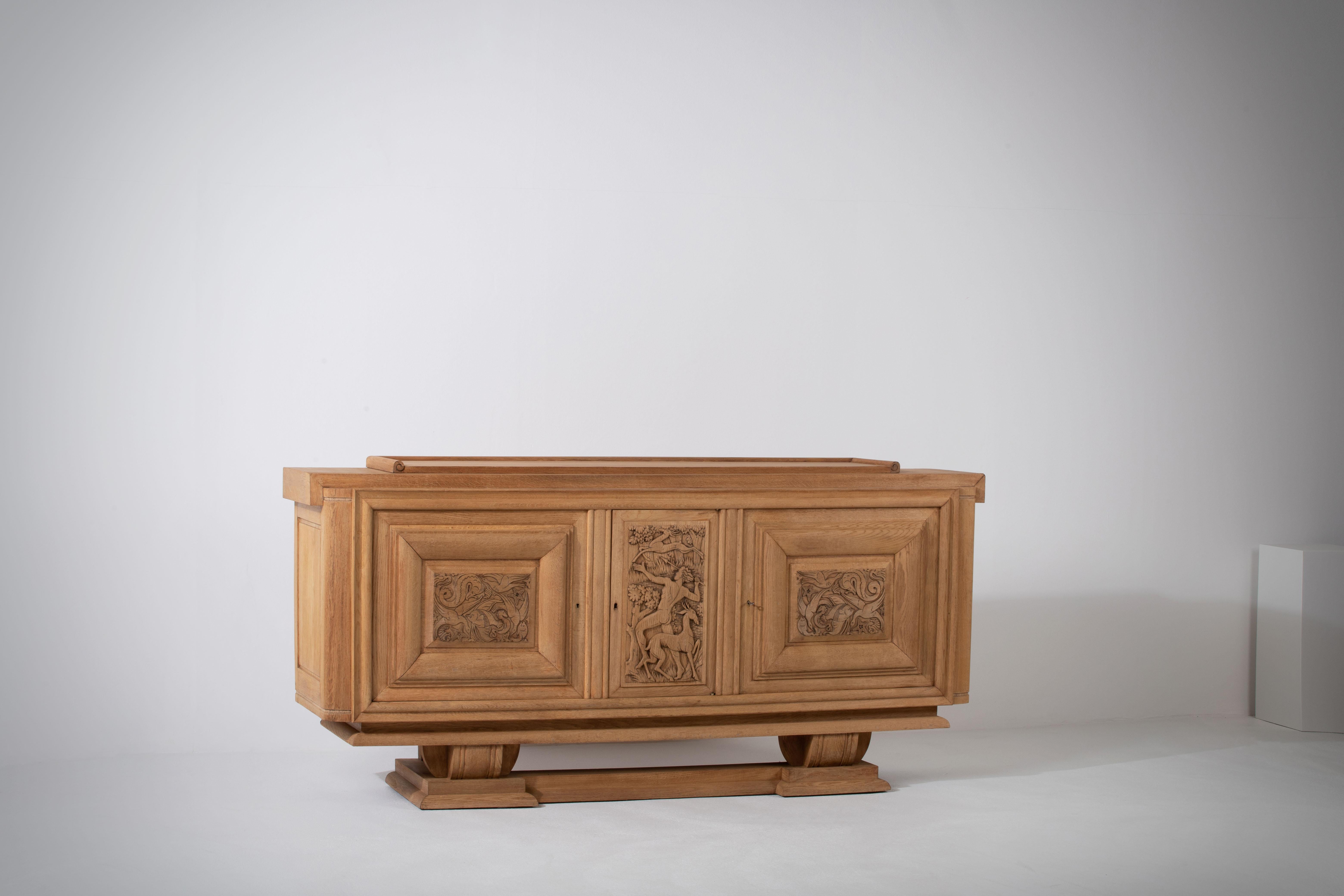 Introducing a remarkable 1940s Art Deco buffet, adorned with a captivating hunting scene meticulously hand carved on its doors. This exquisite piece showcases the fusion of artistry and functionality, creating a truly unique and visually stunning
