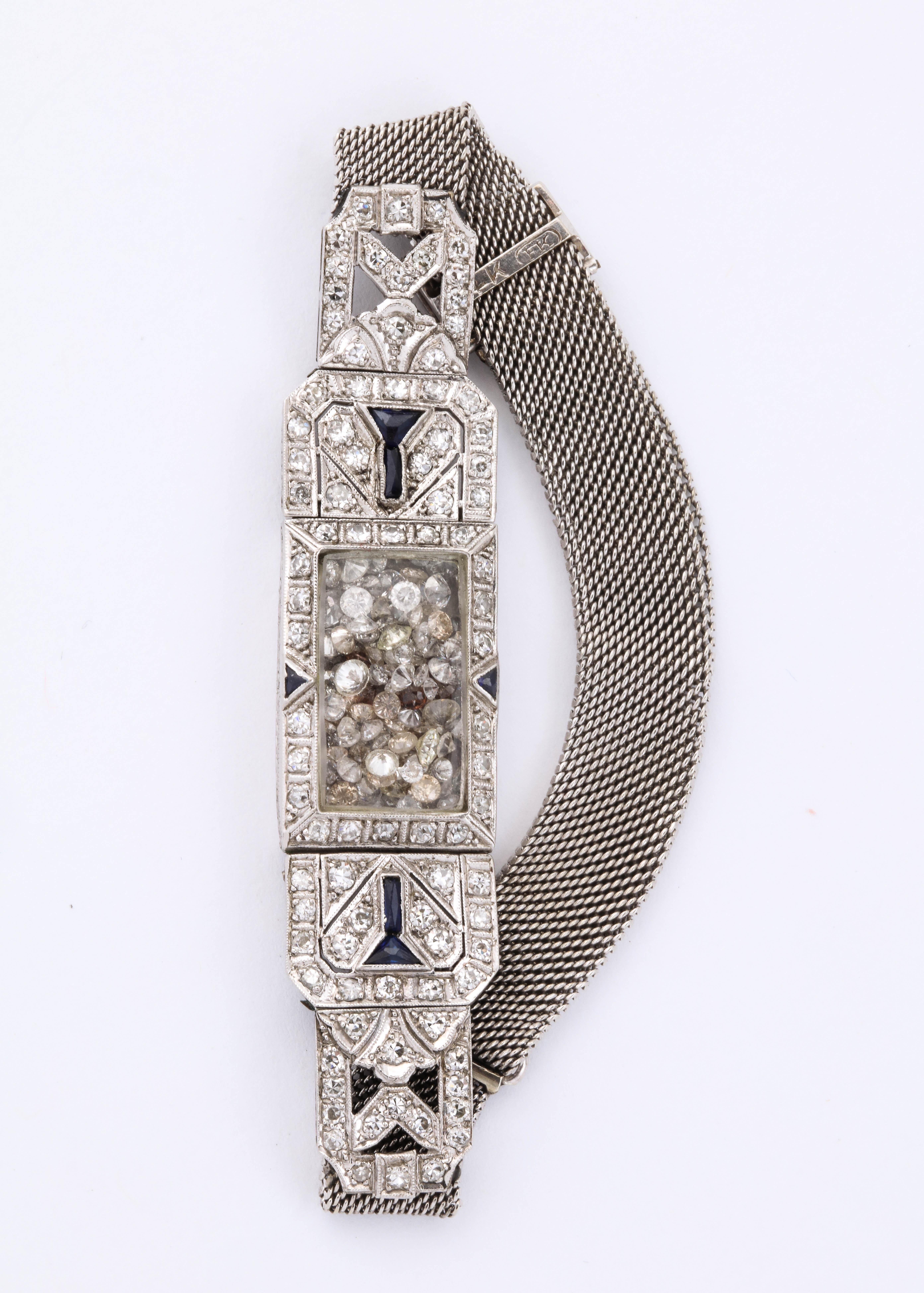 Dies ist eine wiederverwendete Diamant- und Platinuhr, in der 2 Karat alte Diamanten an der Stelle schwimmen, wo der Zeitmesser war.  Die Uhr ist originell mit Diamantplaketten im Deko-Design und einigen Onyx-Akzenten.
Es sieht alleine toll aus und