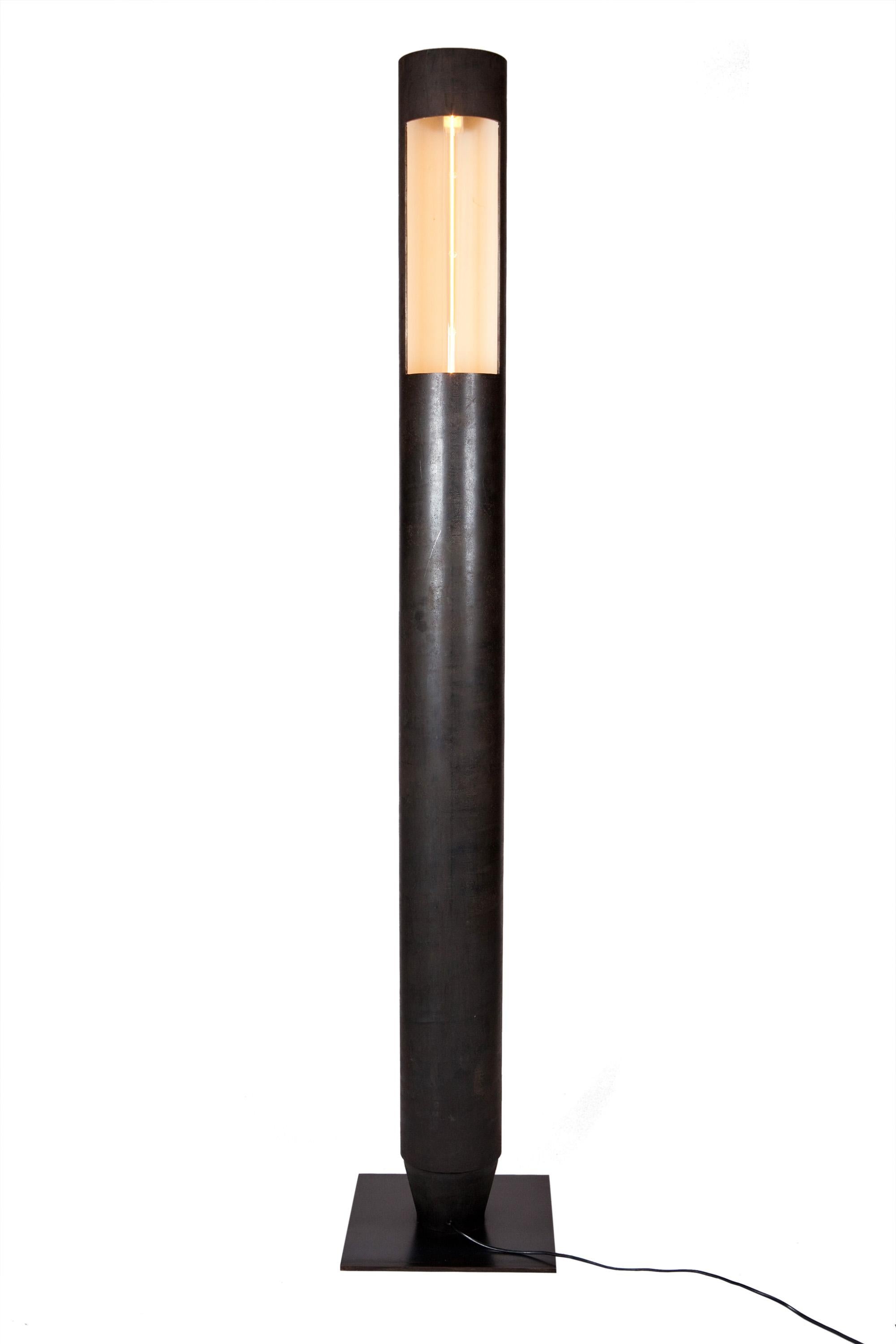 Lámpara de pie de acero en bruto patinado. Interior cubierto con pintura de tiza blanca.
Lámparas led transparentes en el interior.