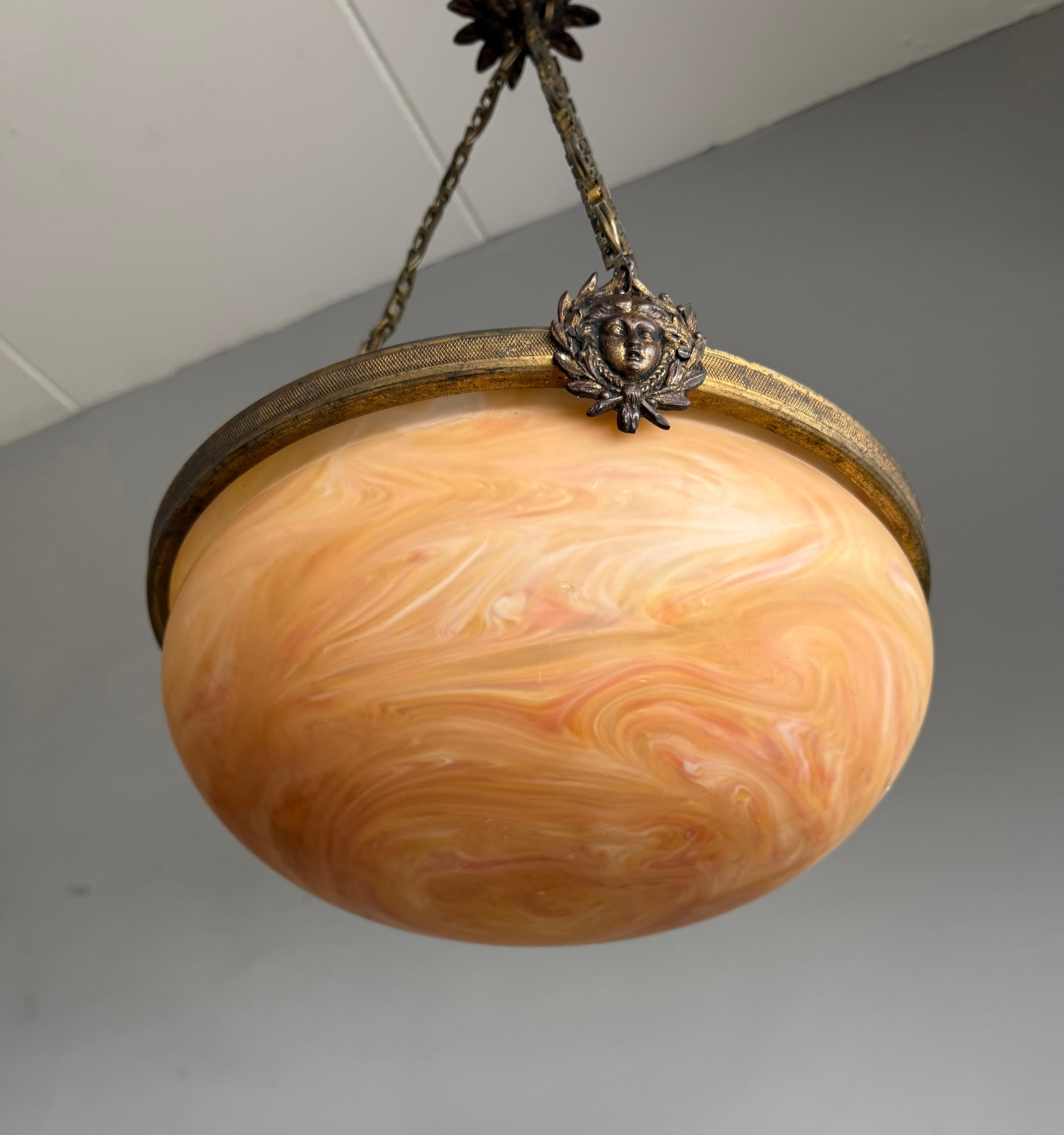 XX secolo Luce a sospensione antica francese senza tempo w. Maschere della Dea dorate e vetro ambrato a spirale in vendita