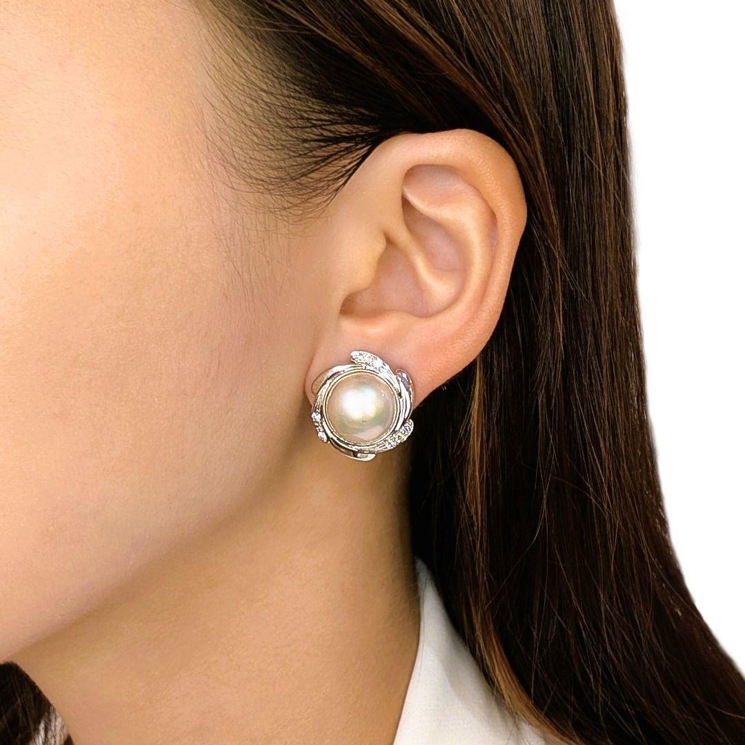 Ces nouvelles boucles d'oreilles allient l'élégance intemporelle à un éclat doux et romantique, avec deux perles de Luminus de couleur champagne (12,8-13,2 mm) serties dans un sculptural or blanc 18 carats. Accentué par 18 diamants ronds brillants
